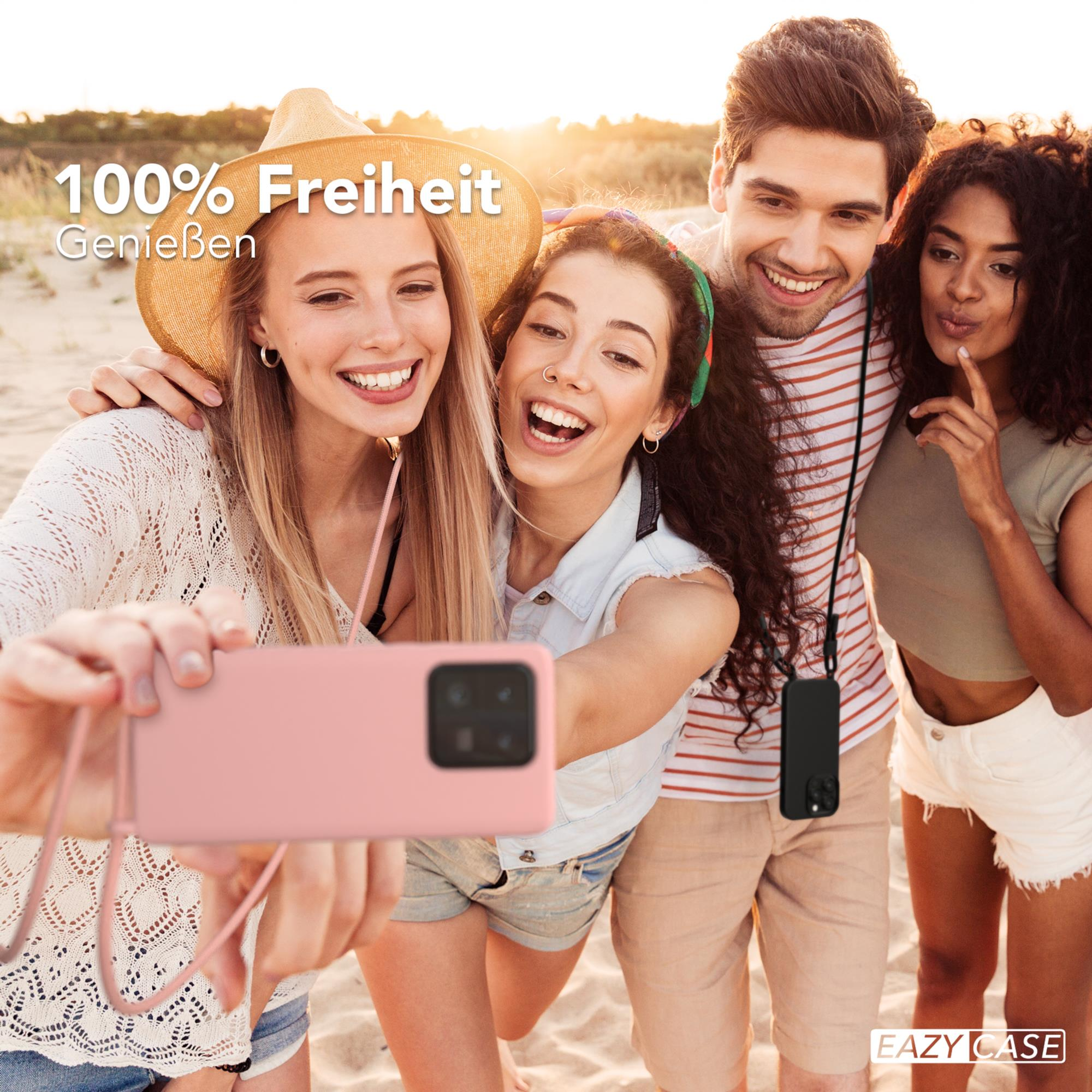 Vier Personen machen ein Selfie am Strand, halten eine rosa Handyhülle. Worte sagen '100% Freiheit'.