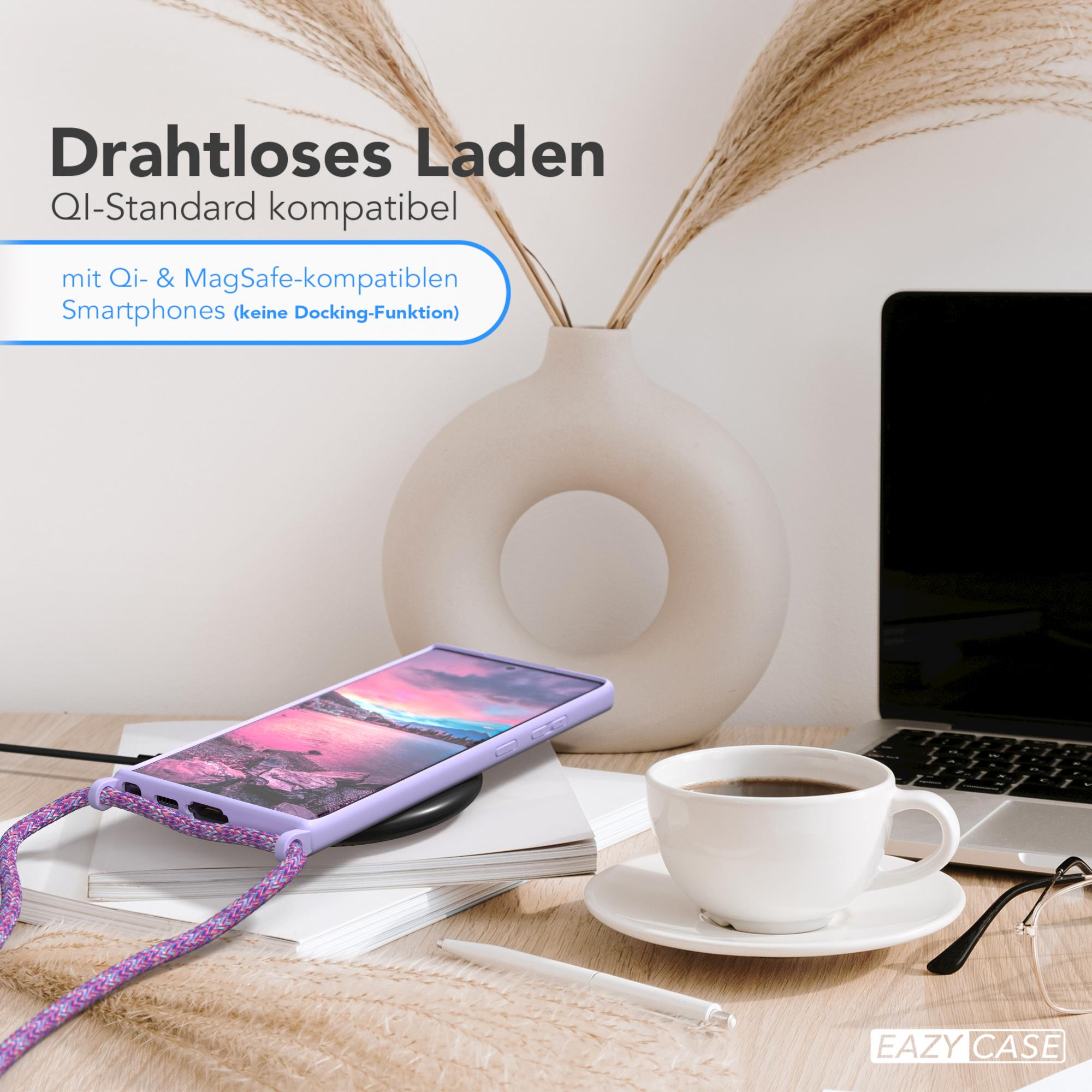 Telefon auf einem kabellosen Ladegerät, Kaffee und Brille auf einem Tisch.