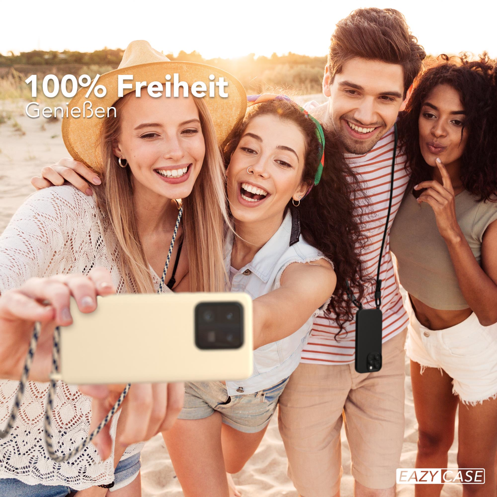 Gruppe von vier Personen macht ein Selfie am Strand. Sie lächeln und halten ein Telefon mit einem Riemen.