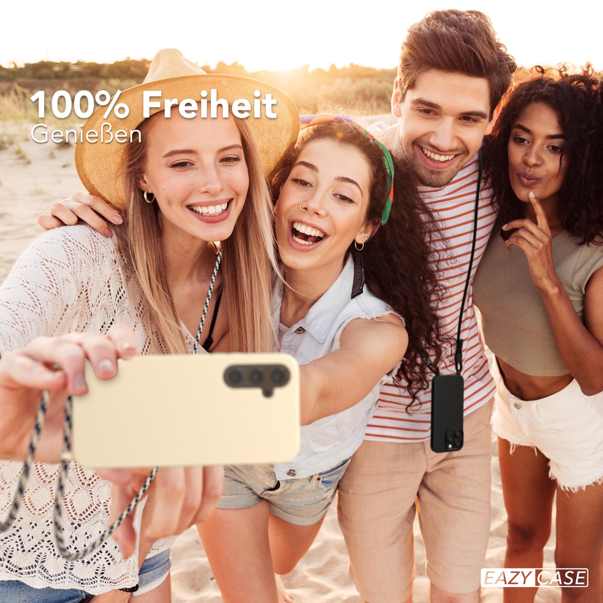 Vier Personen am Strand machen ein Selfie. Einer hält ein beiges Telefon mit einem Riemen.