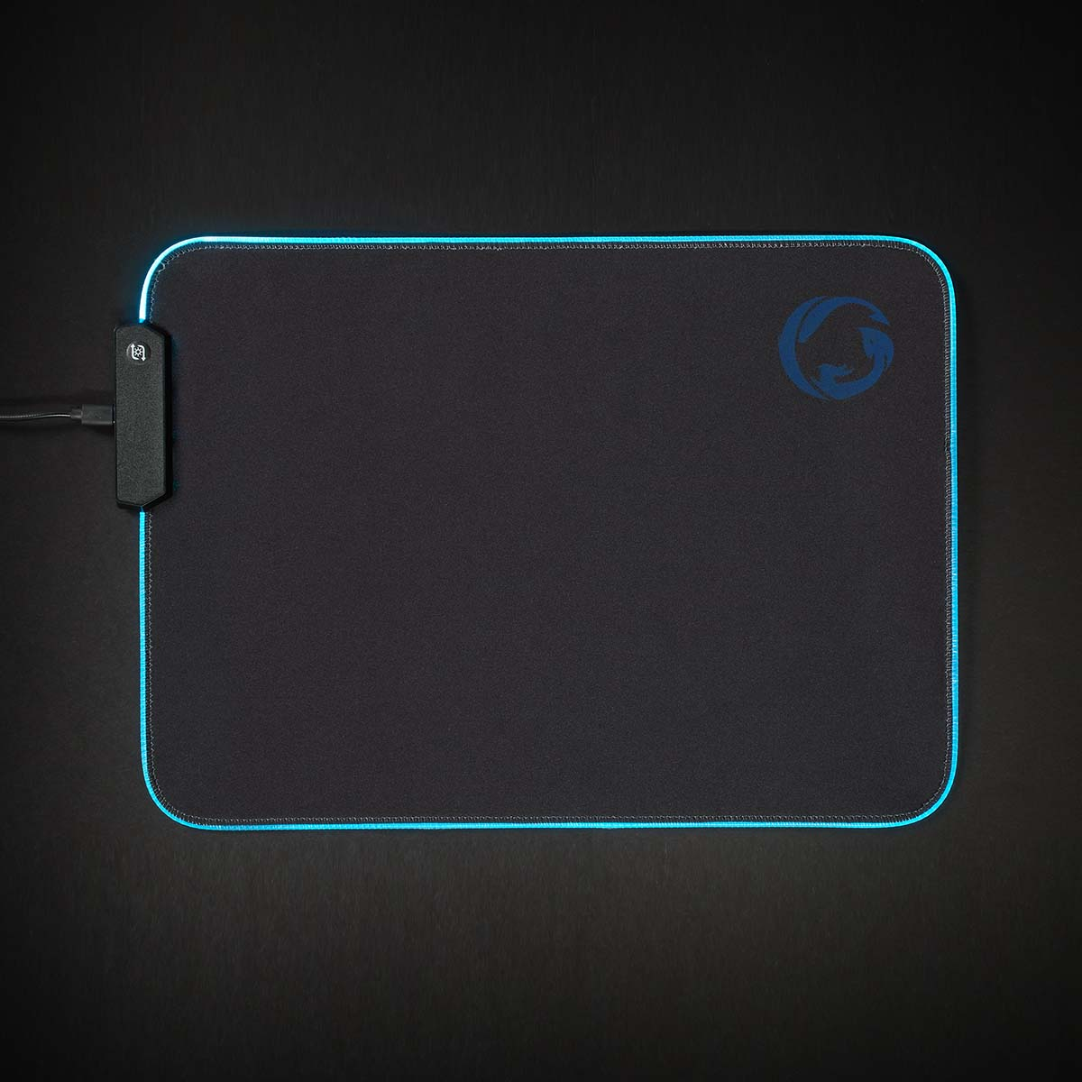 Czarna podkładka pod mysz z niebieską obwódką LED i logo. Przewód z kontrolerem po lewej stronie.