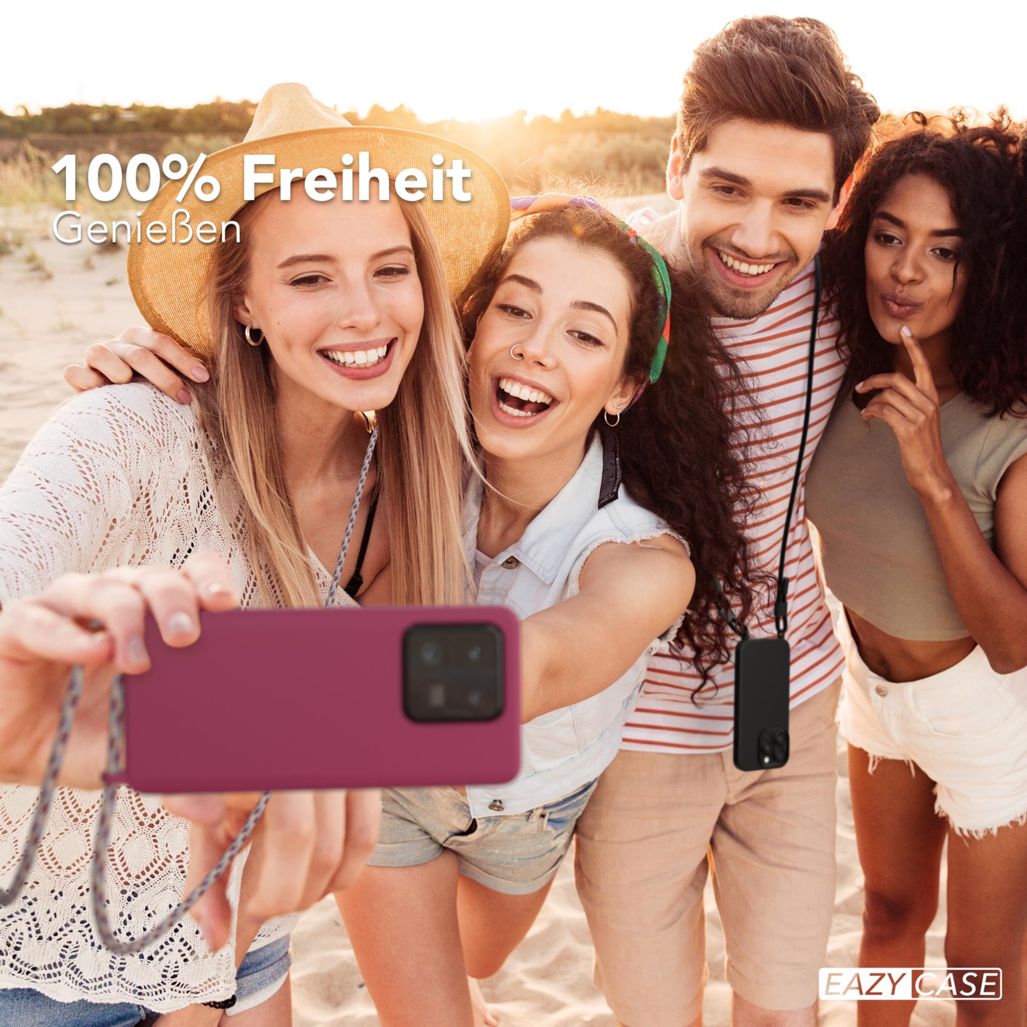 Vier Personen machen Selfie am Strand, zwei halten Handy mit Hülle.