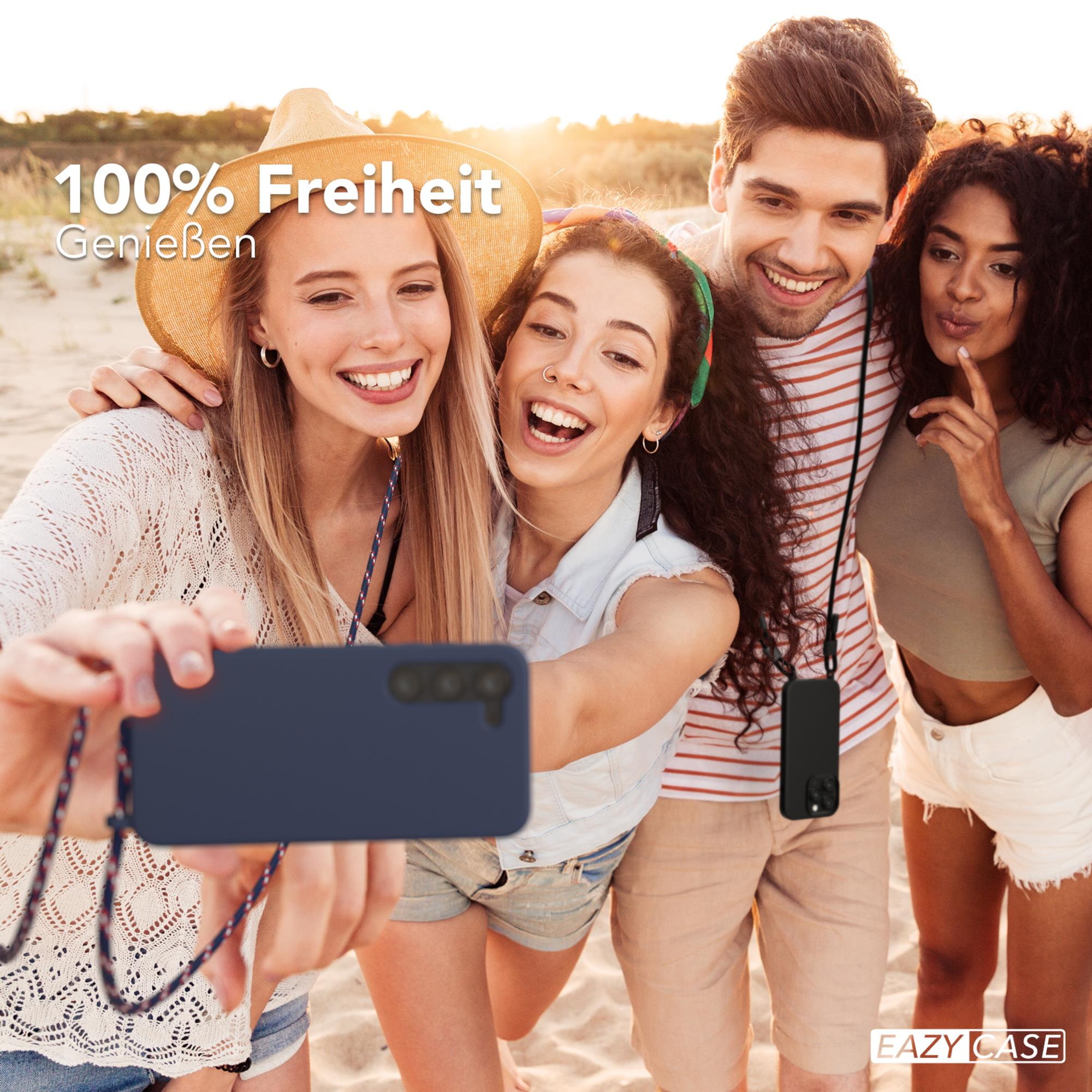 Eine Gruppe von vier Personen macht ein Selfie am Strand.
