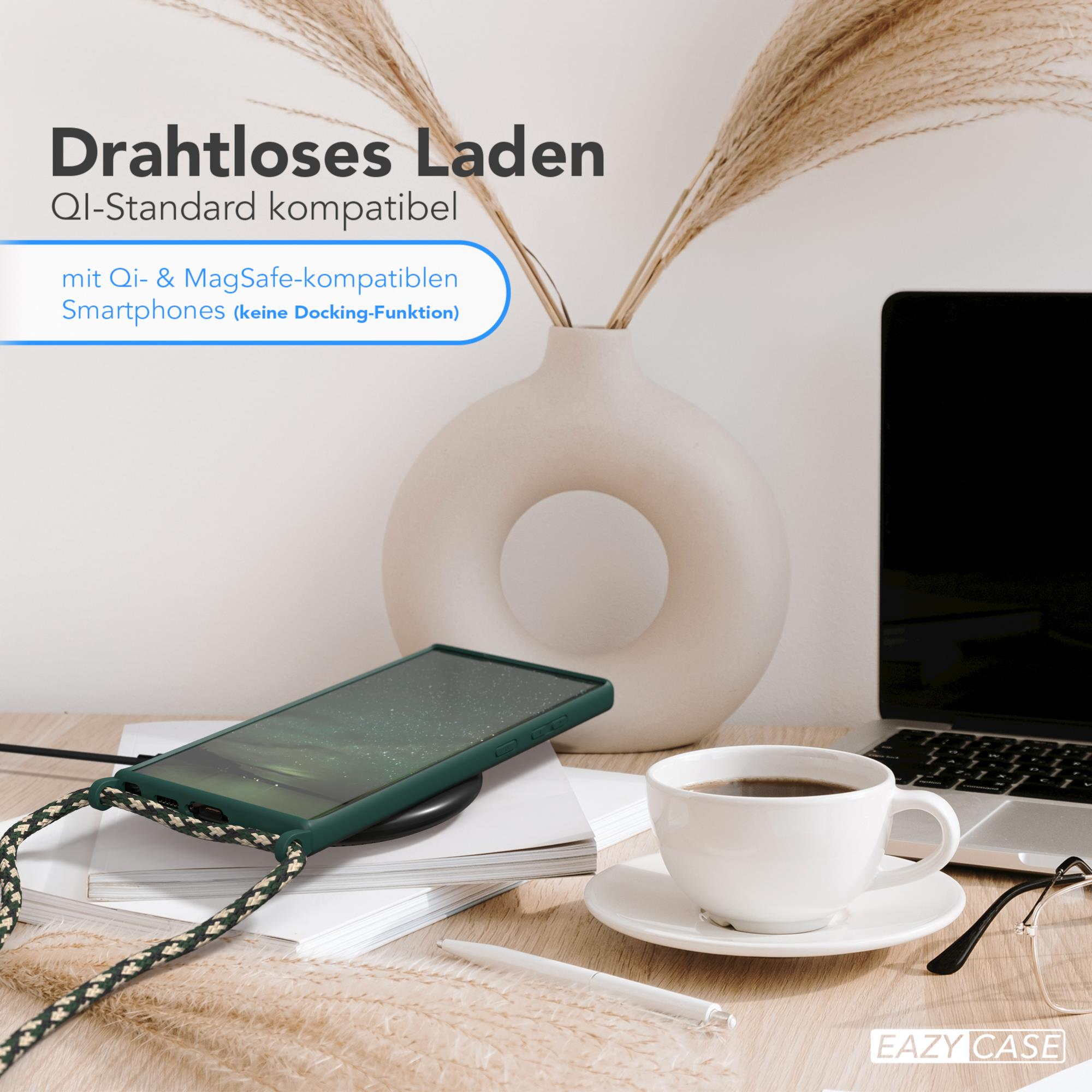 Ein Telefon wird kabellos auf einem Holztisch geladen. Eine Tasse Kaffee und eine Vase sind in der Nähe.