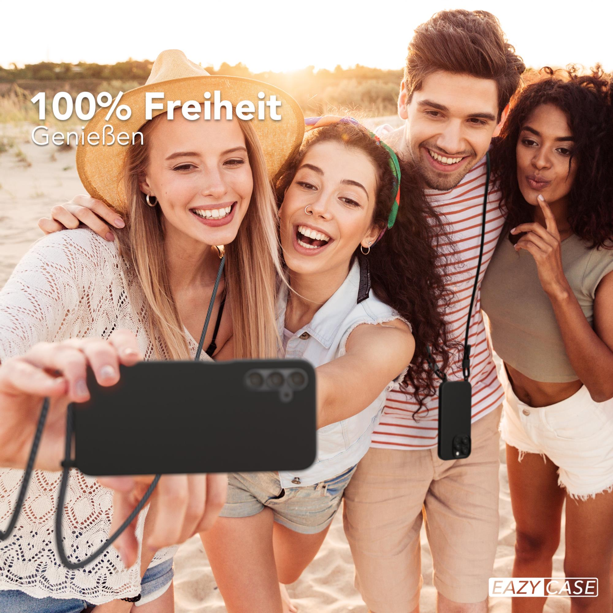 Vier Personen machen ein Selfie am Strand, halten ein Telefon mit Hülle.