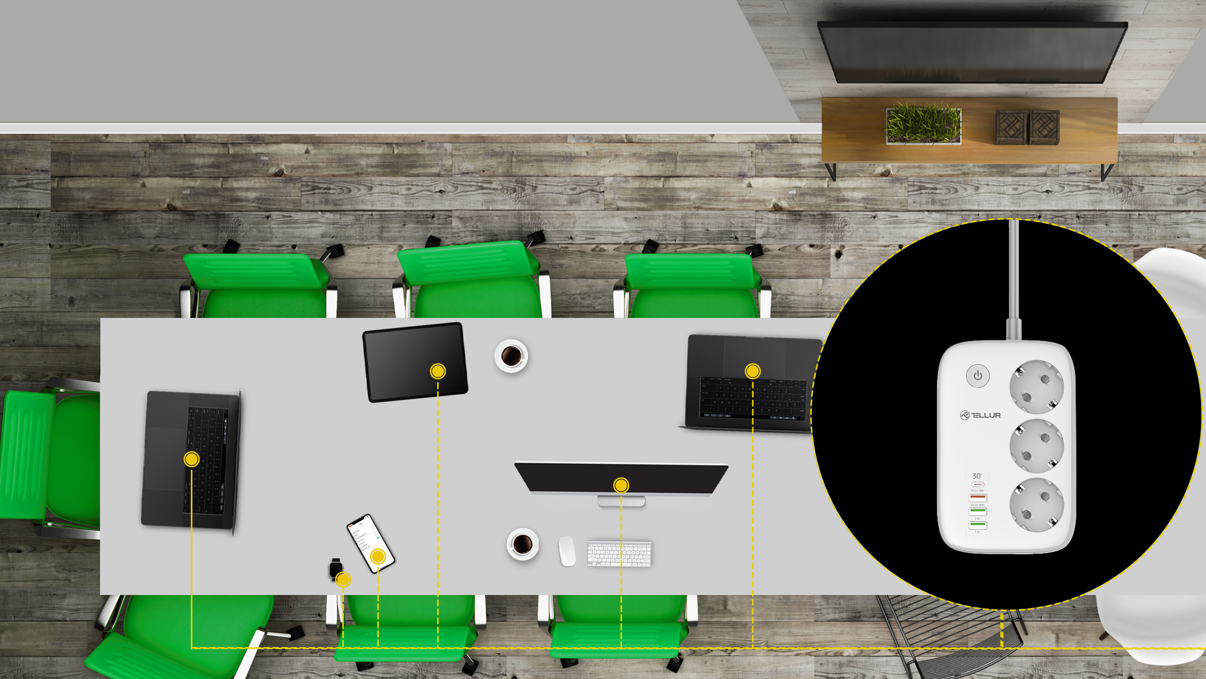 Widok z góry na stół konferencyjny z laptopami, telefonami i listwą zasilającą z wtyczkami.