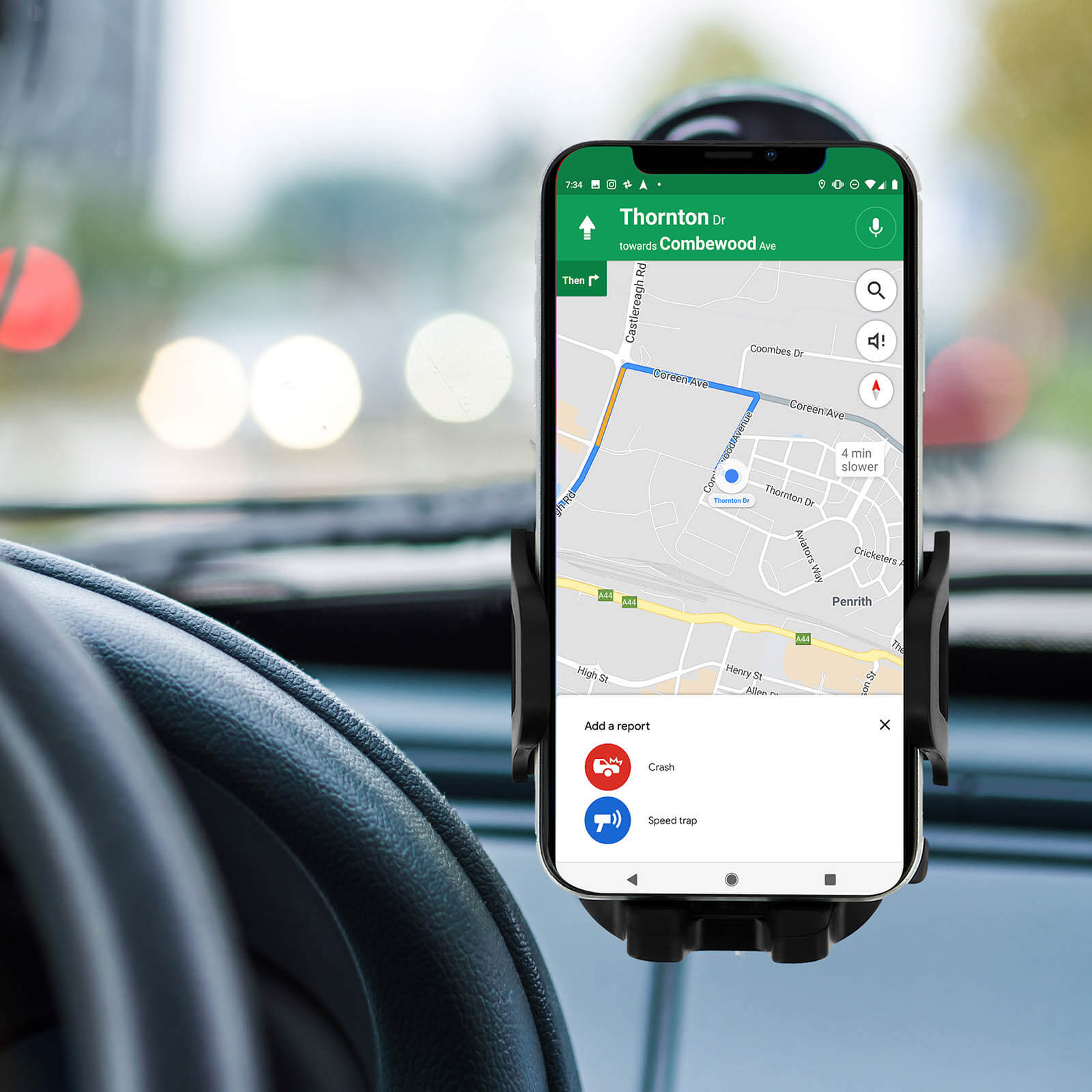 Un telefono in un supporto per auto mostra una mappa con indicazioni stradali. Interni dell'auto visibili.