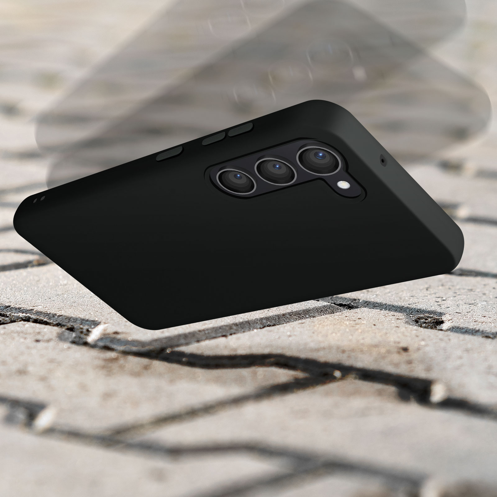 Czarne etui na szorstkiej powierzchni. Telefon upada. Potrójny aparat widoczny. Efekt dynamiczny.