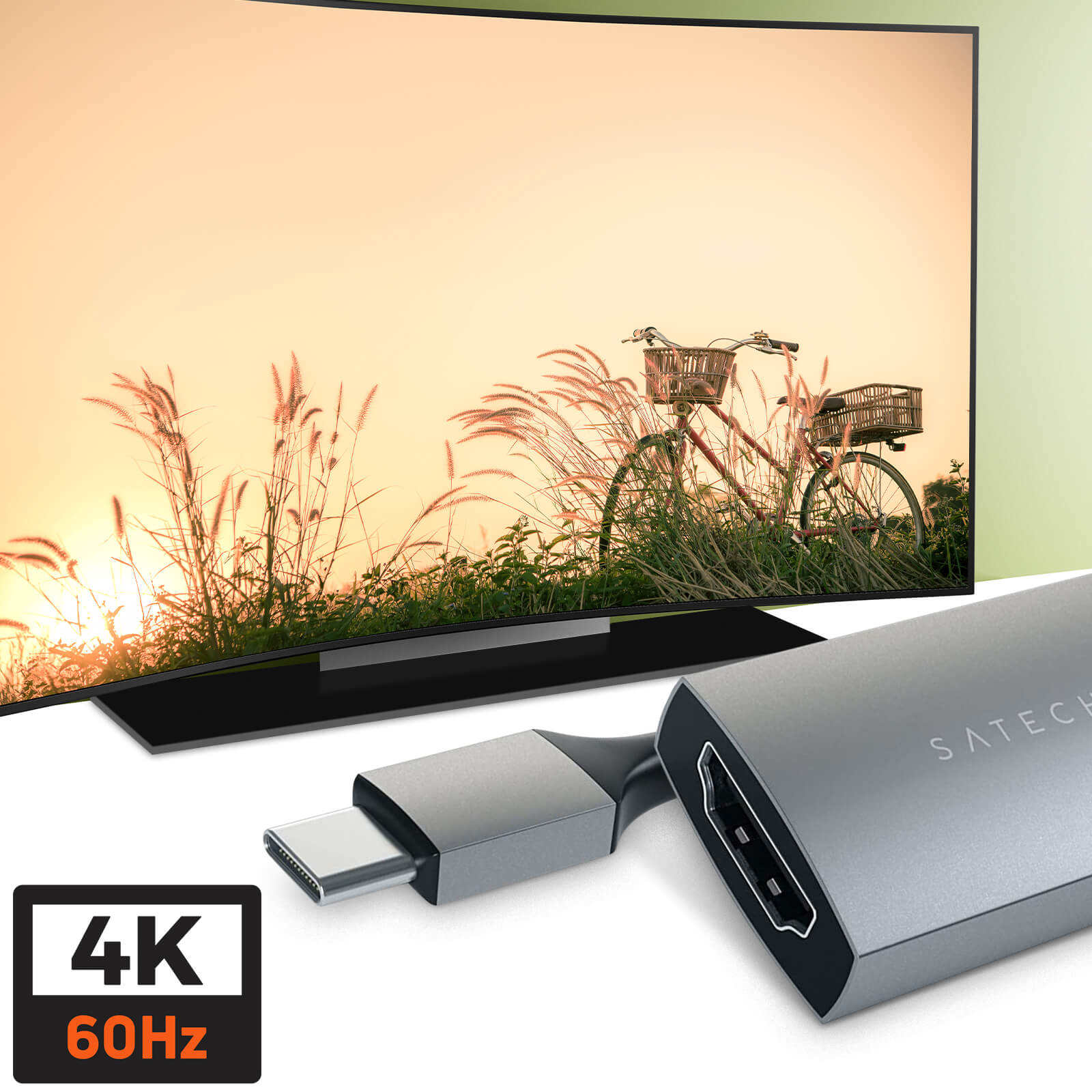 Fernseher mit Sonnenuntergangsszene und silbernem HDMI-Adapter. 4K 60Hz Logo unten links.