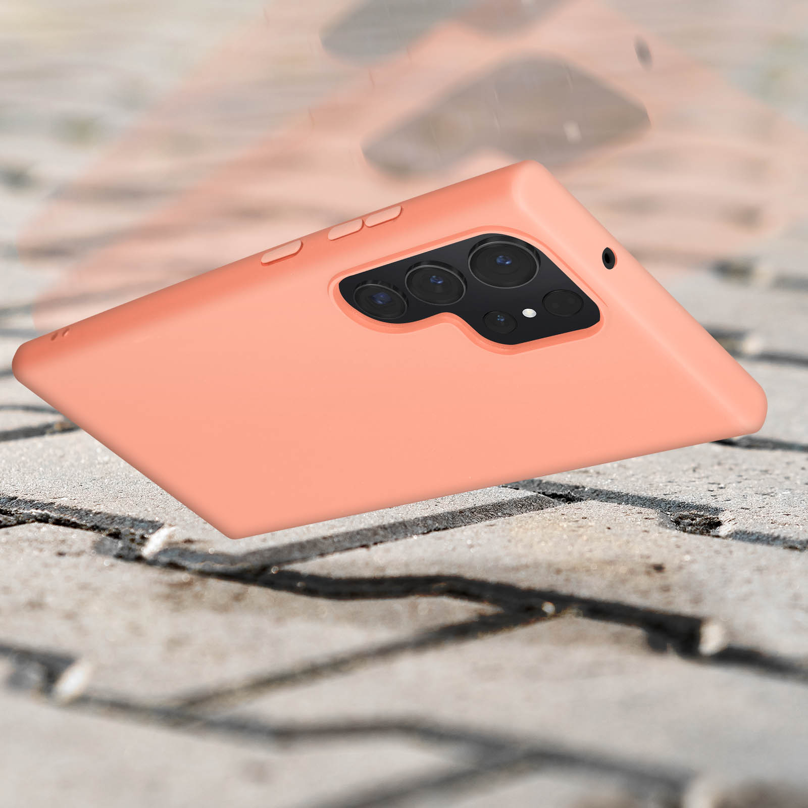 Pomarańczowe etui na telefon spadające na teksturowaną powierzchnię, z rozmytym tłem.