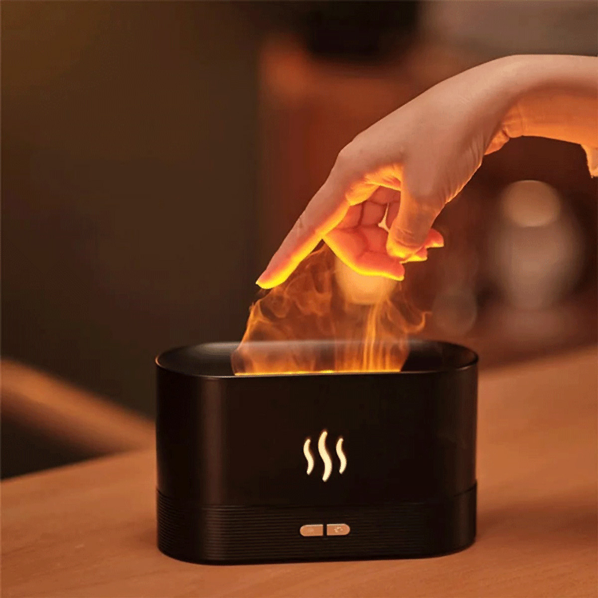 Difusor de aroma negro en forma de llama. Mano apuntando al efecto de llama.