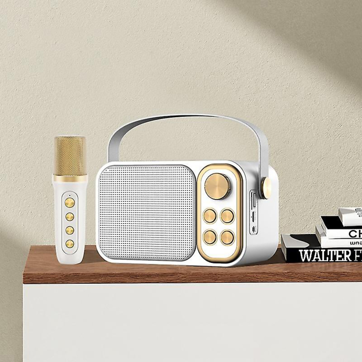 Radio blanco y dorado con un micrófono, sobre una superficie de madera cerca de libros.