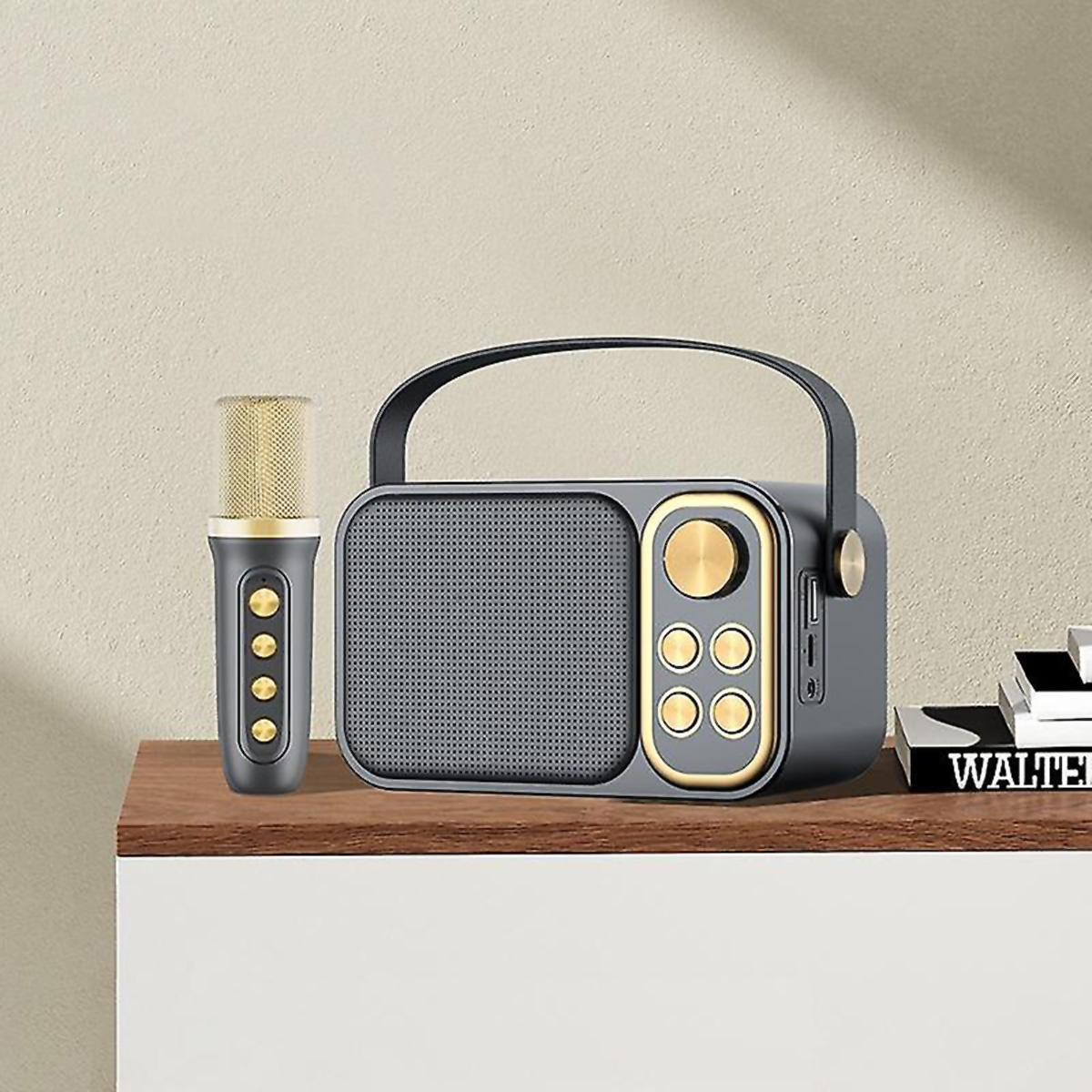 Altavoz gris con micrófono en una estantería. Libros a la derecha.