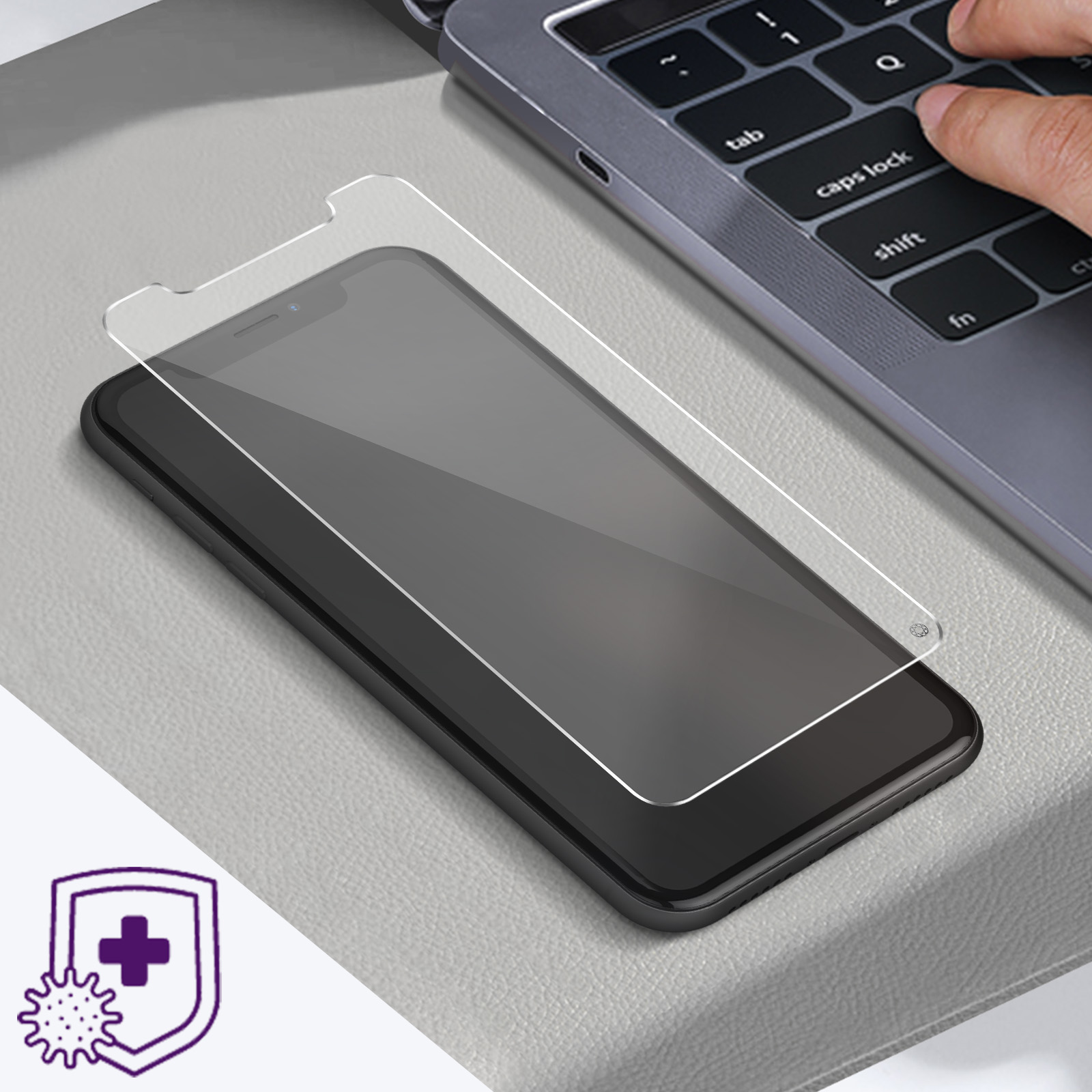 Een telefoon met een schermbeschermer en een laptoptoetsenbord. Een hand staat op het punt een toets in te drukken.