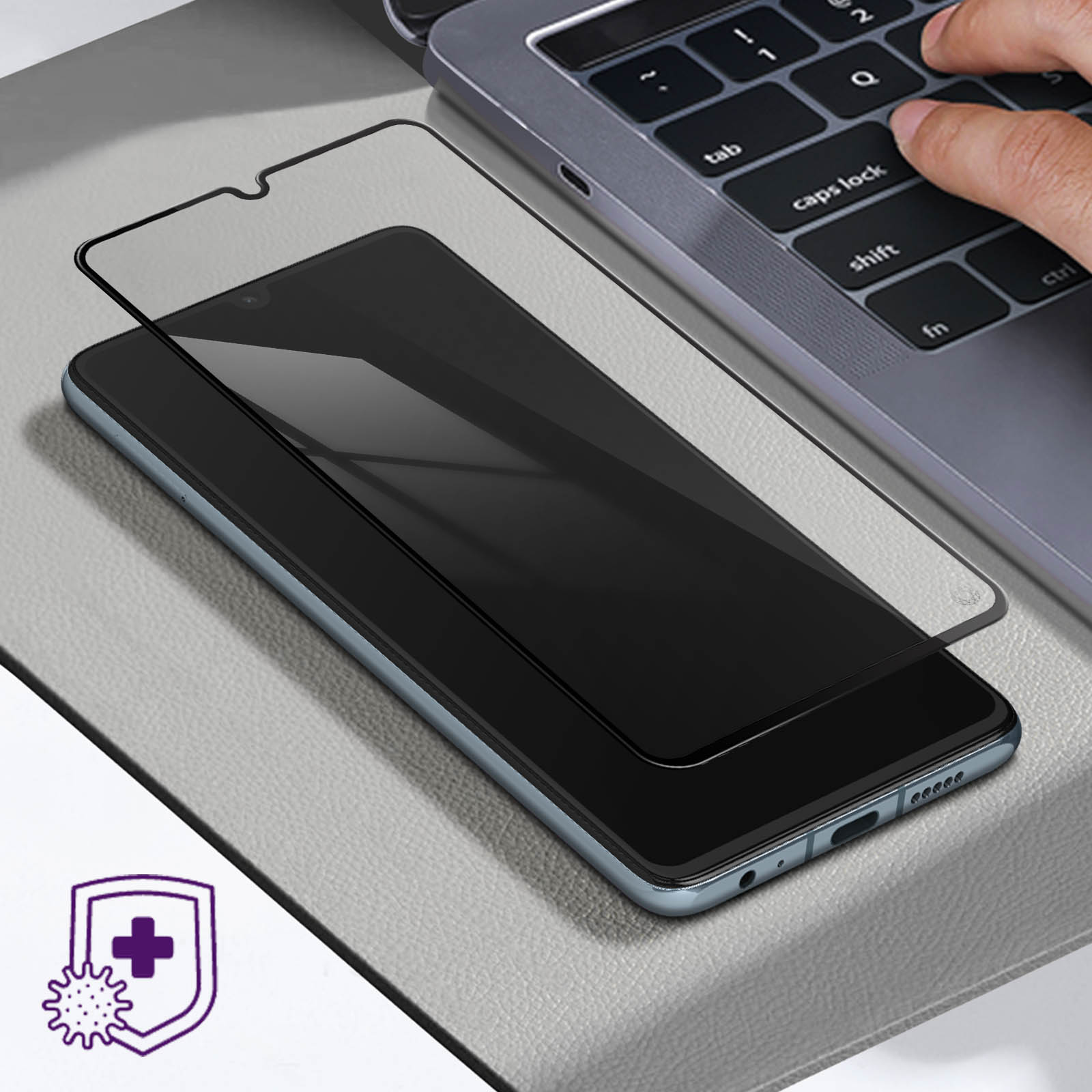 Un telefono con protezione schermo, una tastiera di un laptop sullo sfondo e un'icona di virus.