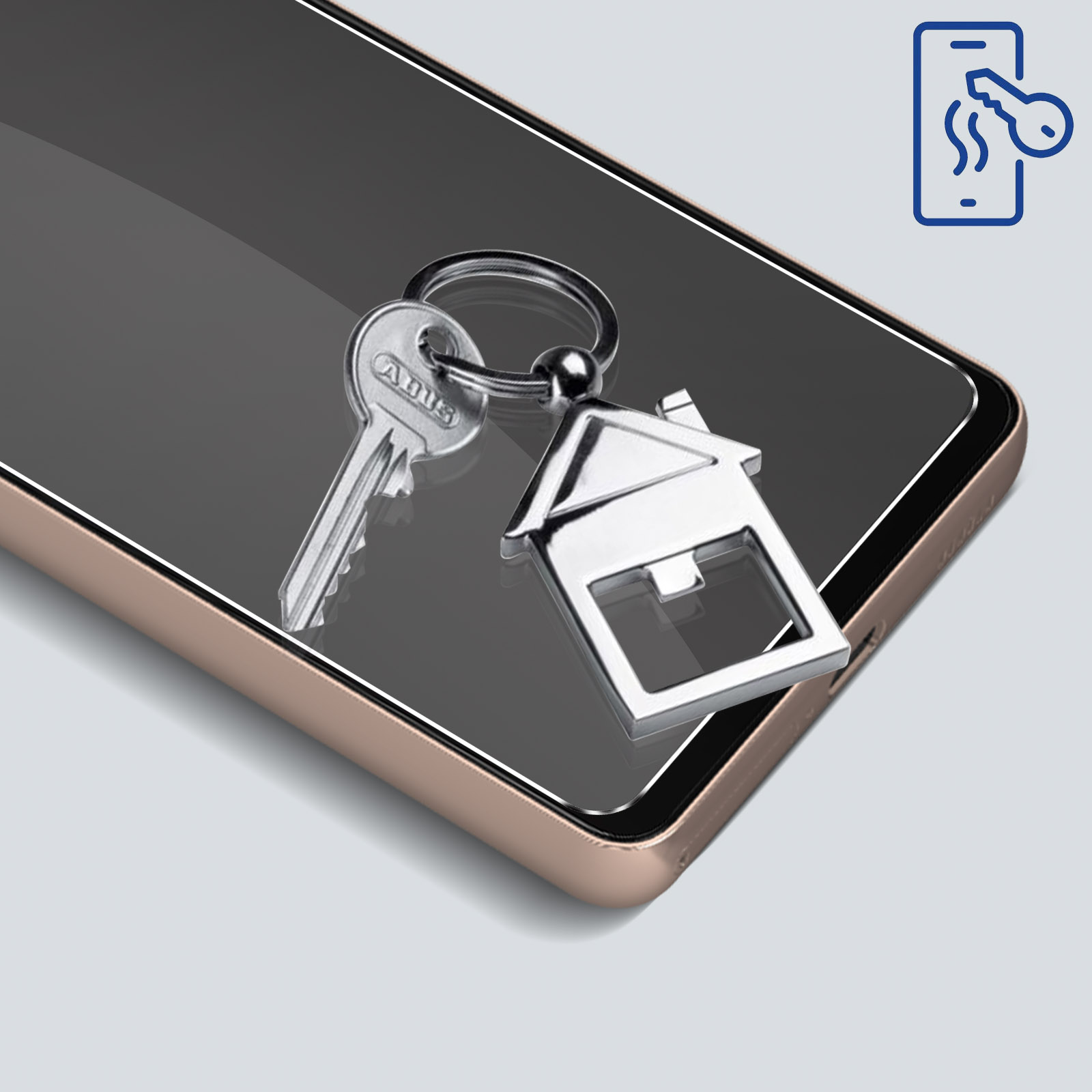 Klucze i brelok w kształcie domu na telefonie z ochroną ekranu. Telefon leży na jasnej powierzchni.