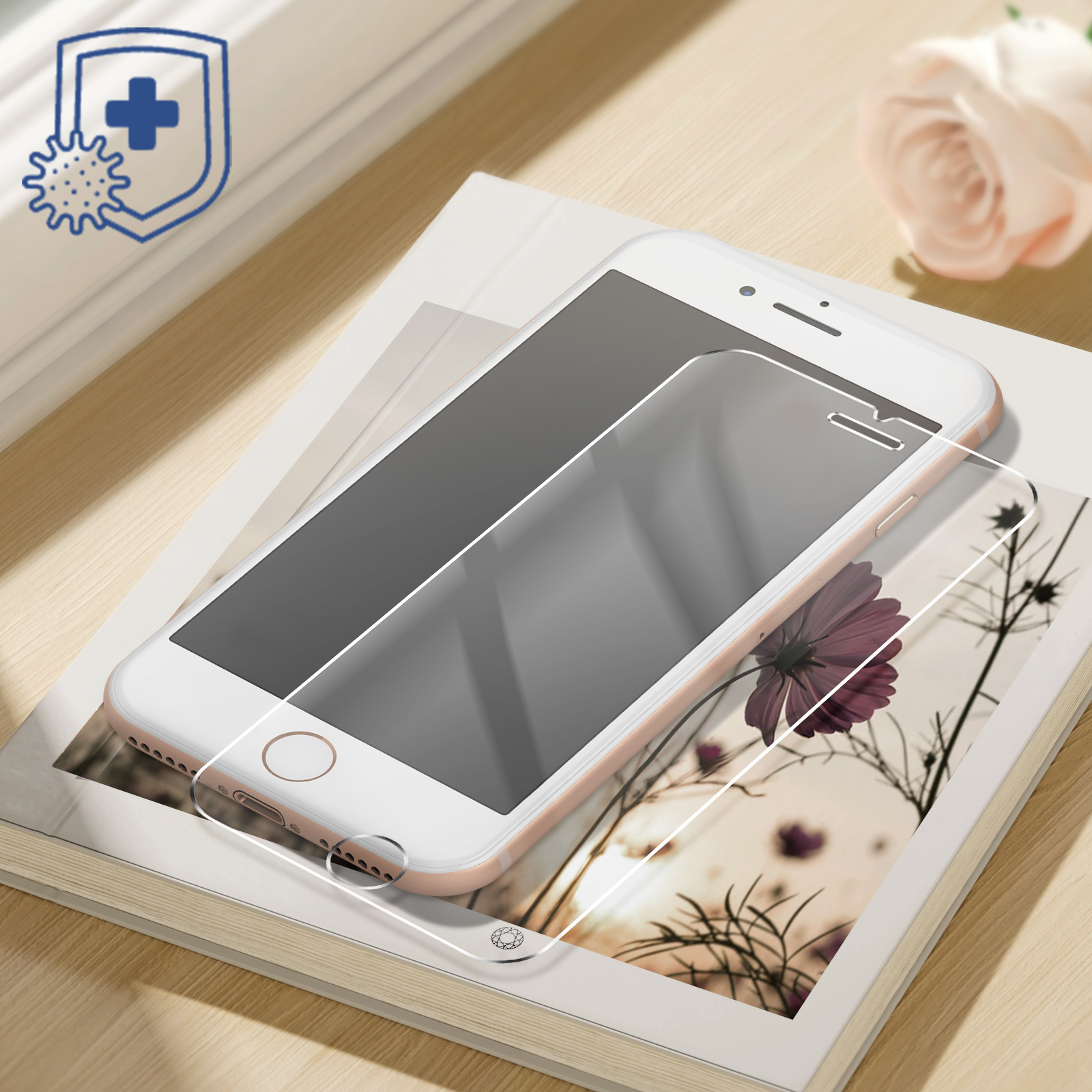 Phone with screen protector applied, sitting on a book with a flower.