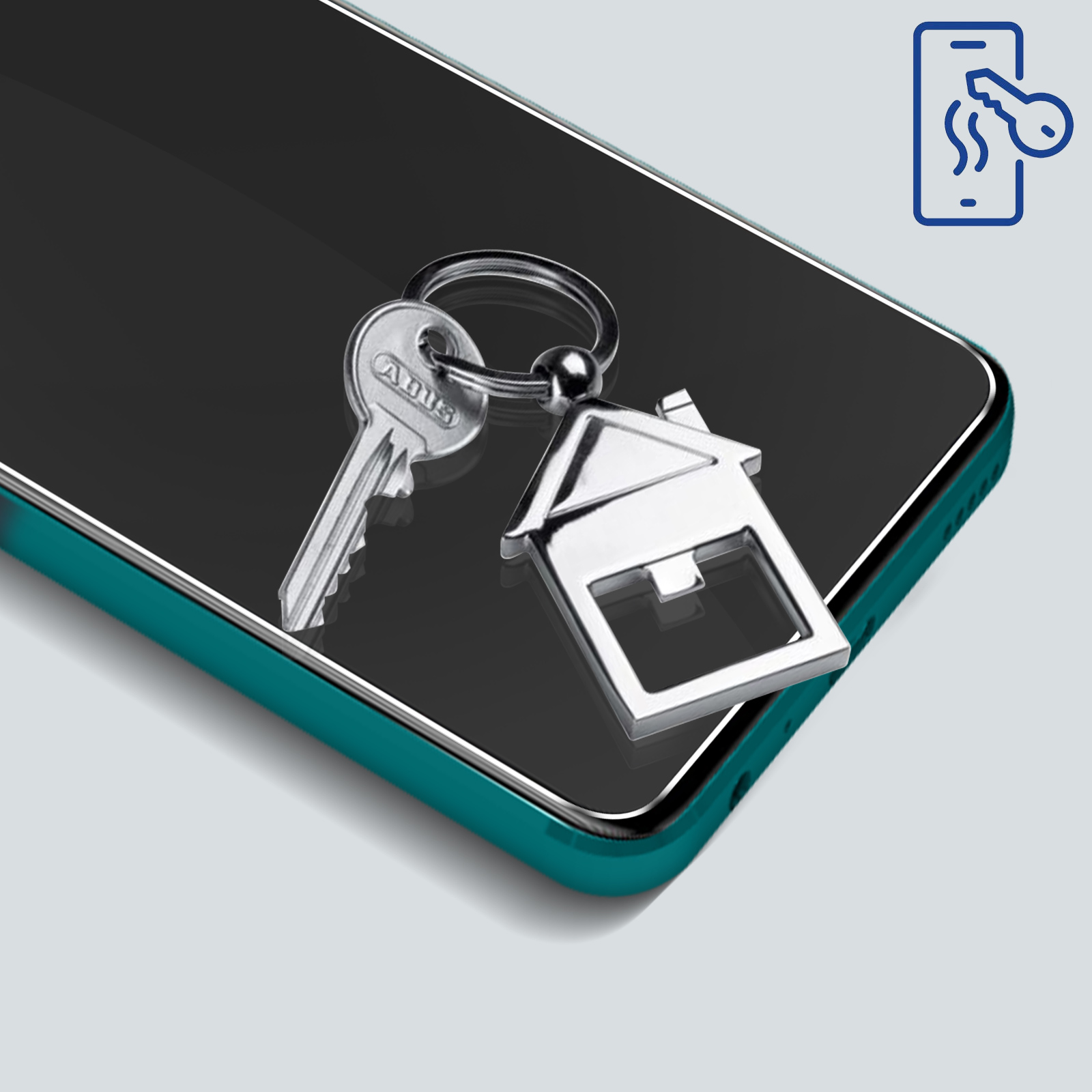 Telefon z kluczami i brelokiem w kształcie domu. Telefon ma turkusową ramkę. Tło jest jasnoszare.