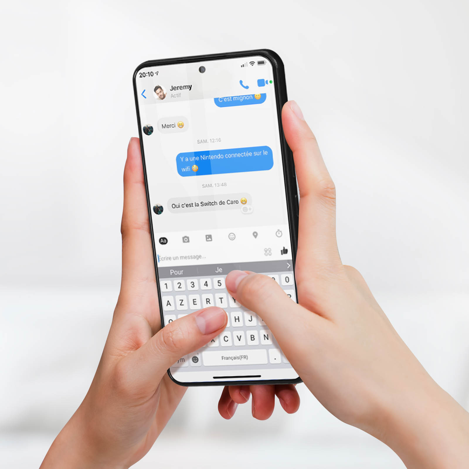 Mani che tengono un telefono, che mostra una conversazione testuale. Il testo è in francese.