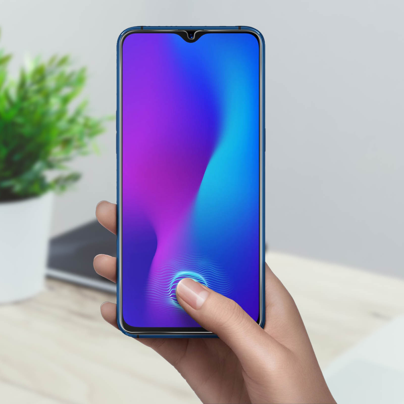 Una mano tiene un telefono con schermo blu e viola. Un dito tocca il sensore di impronte digitali.