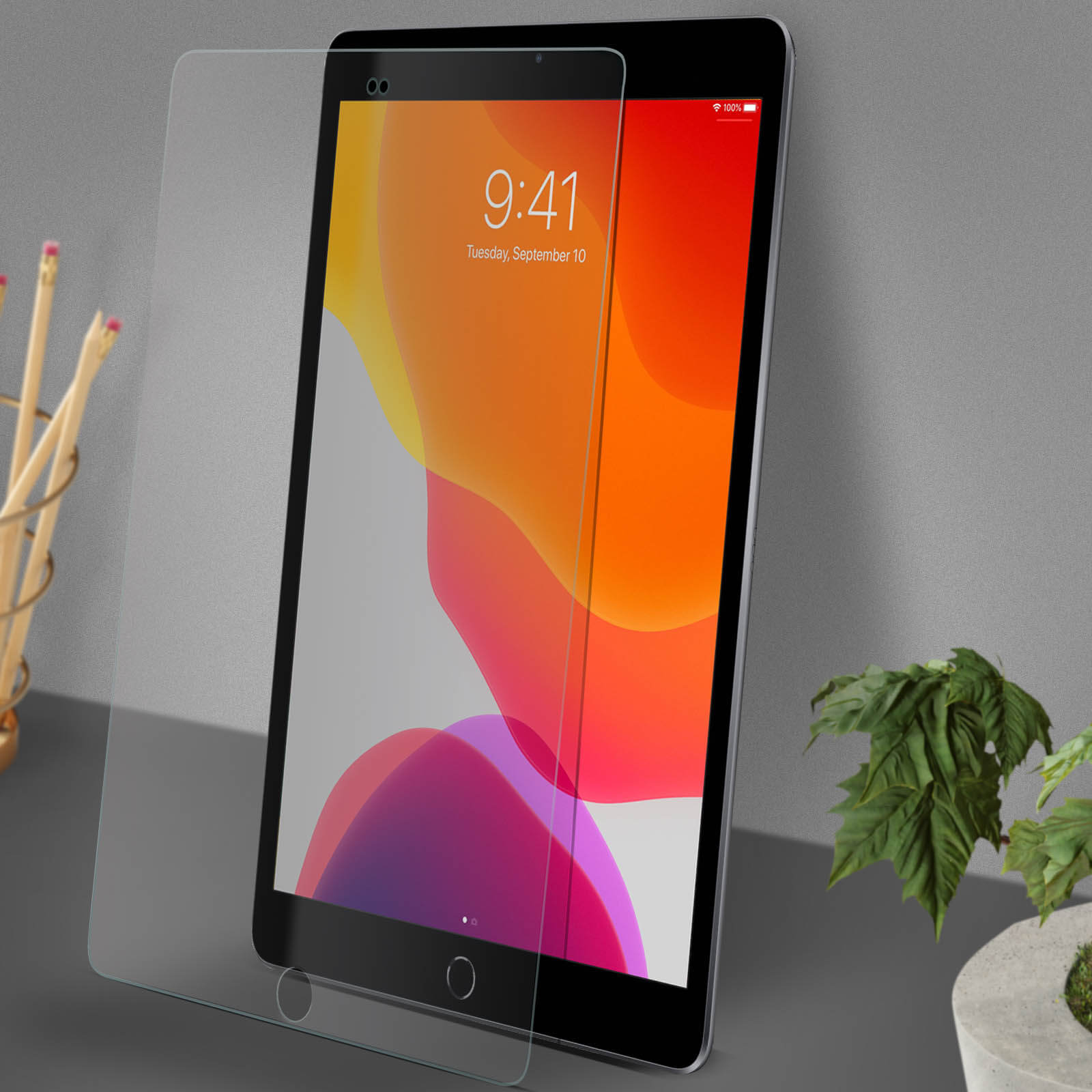 Tablet z ochraniaczem ekranu na biurku. Ekran pokazuje zegar.