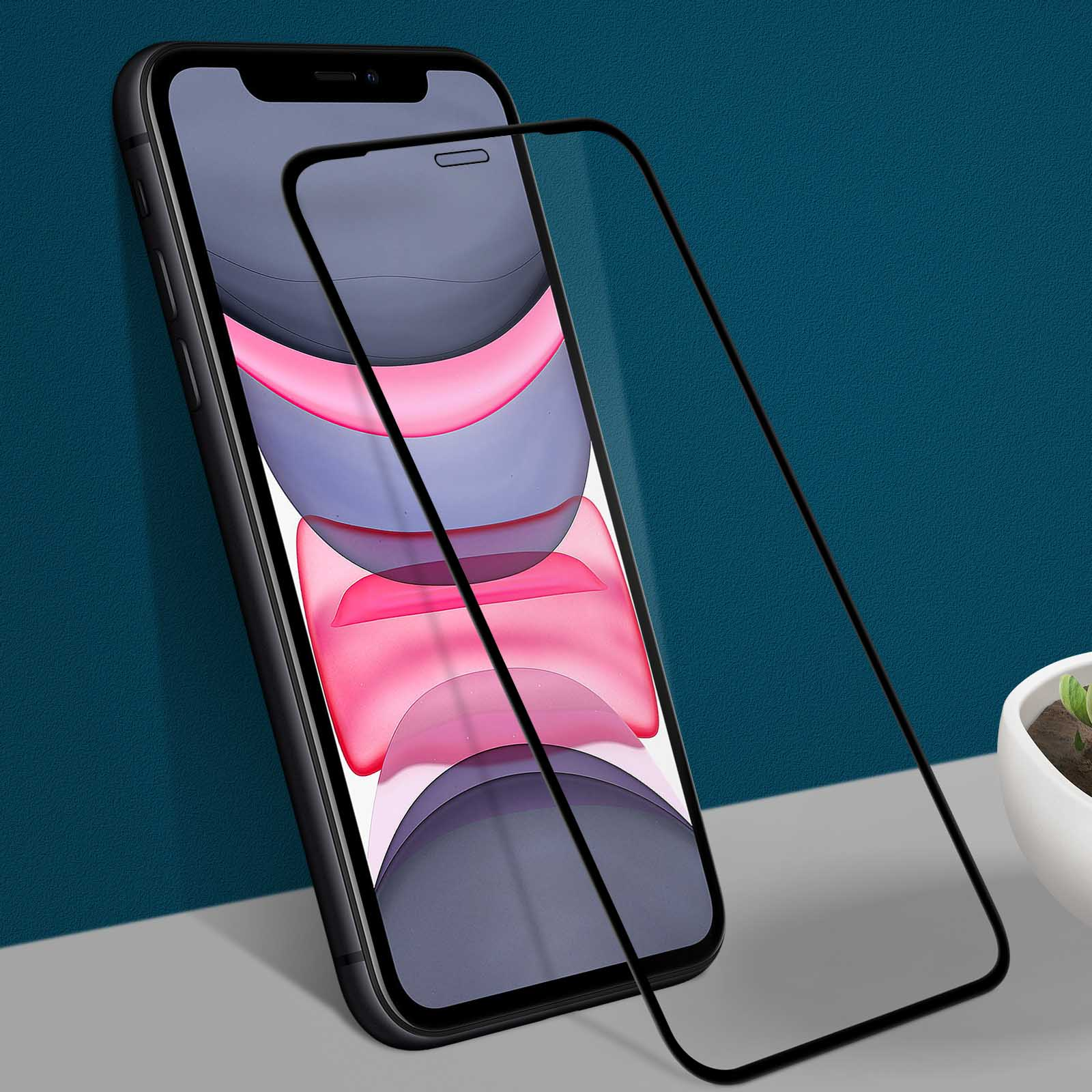 Uno smartphone nero con una protezione per lo schermo. Il telefono è nero, la protezione è trasparente e lo sfondo è verde acqua e grigio.