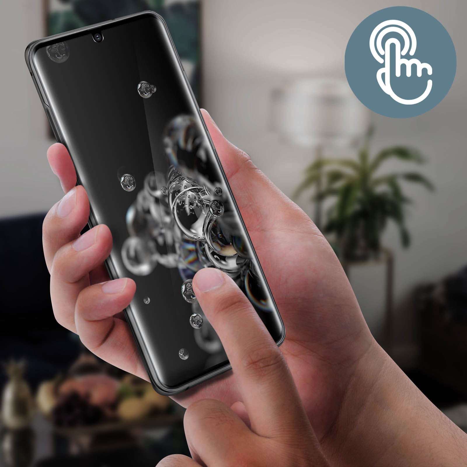 Una mano che tiene uno smartphone nero con gocce d'acqua sullo schermo. Un altro dito tocca lo schermo. Lo sfondo è sfocato.