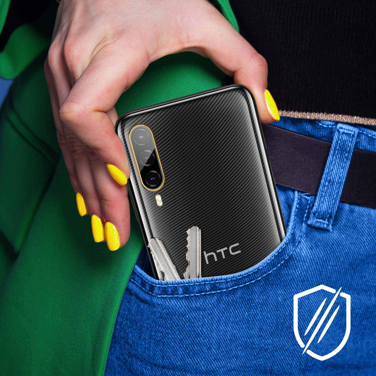 Dłoń kobiety trzyma czarny telefon, klucze w kieszeni. Widoczne żółte paznokcie, niebieskie dżinsy i zielona kurtka.