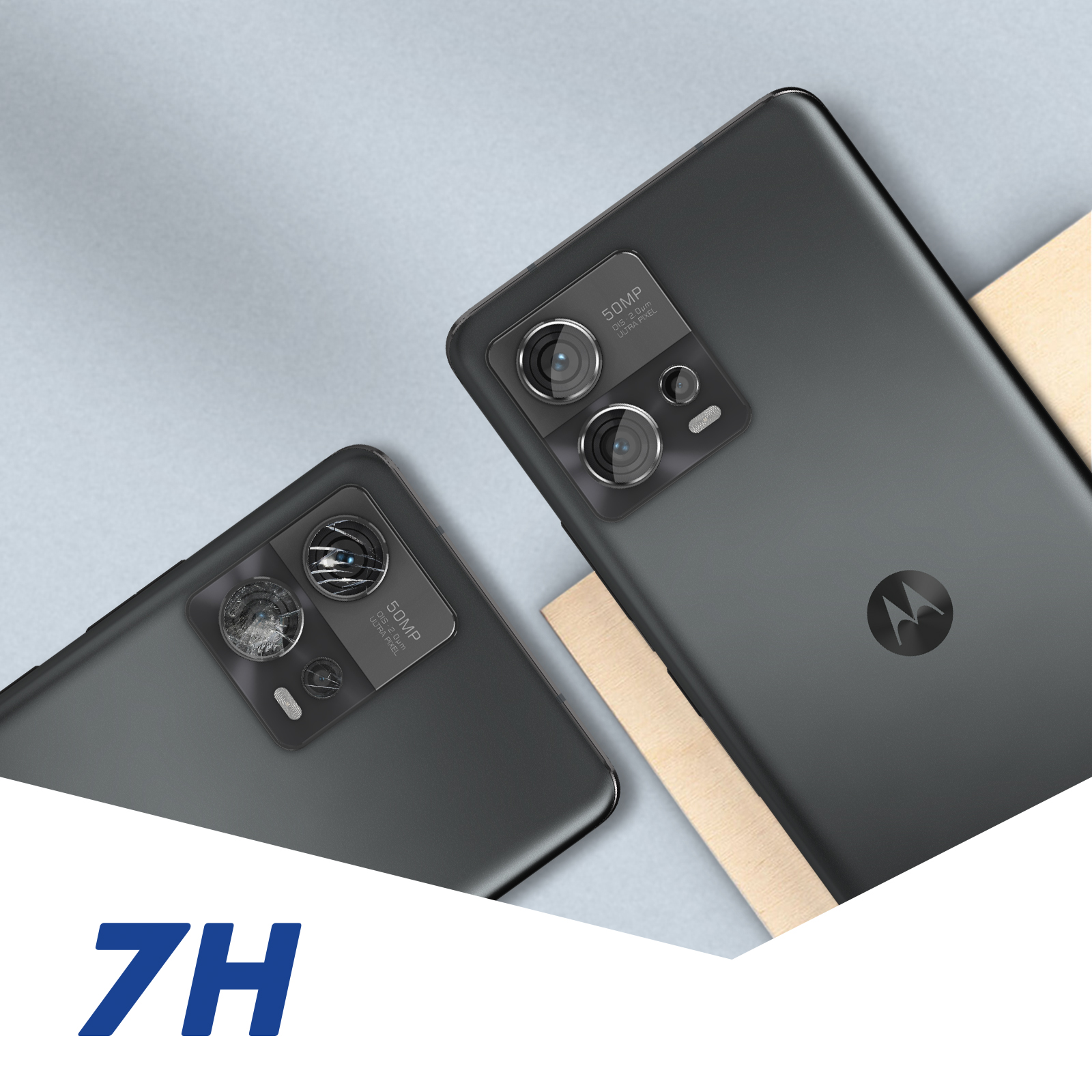 Dwa szare telefony z wypukłymi aparatami. Tekst 7H na dole, na tle jasnoszarym i drewnianym.