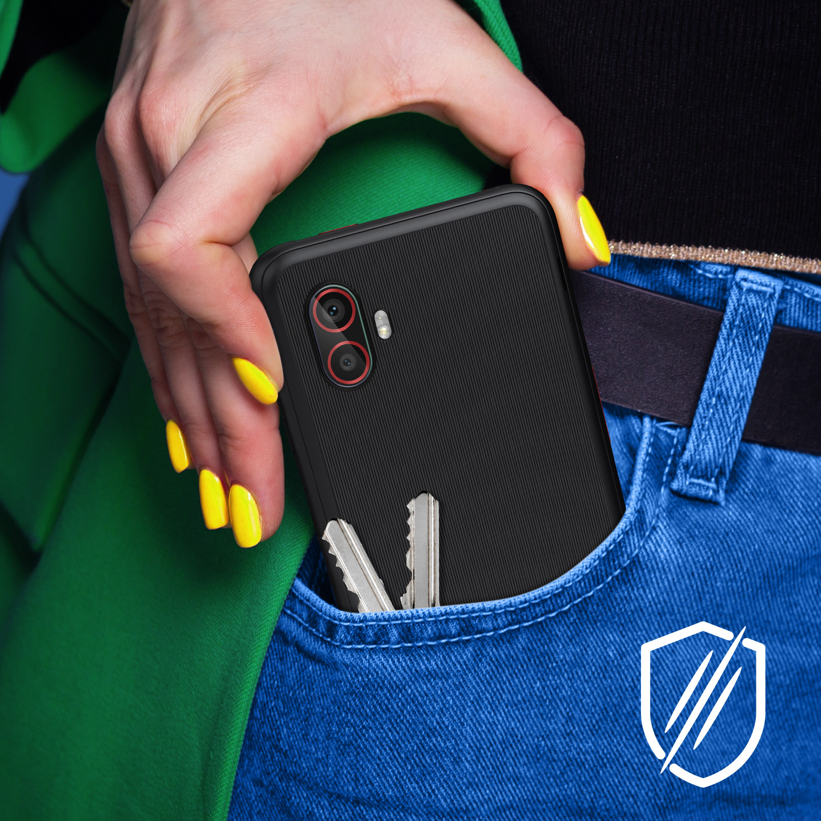 Dłoń trzyma czarny telefon, klucze w kieszeni. Telefon ma kamery z czerwonymi obwódkami.