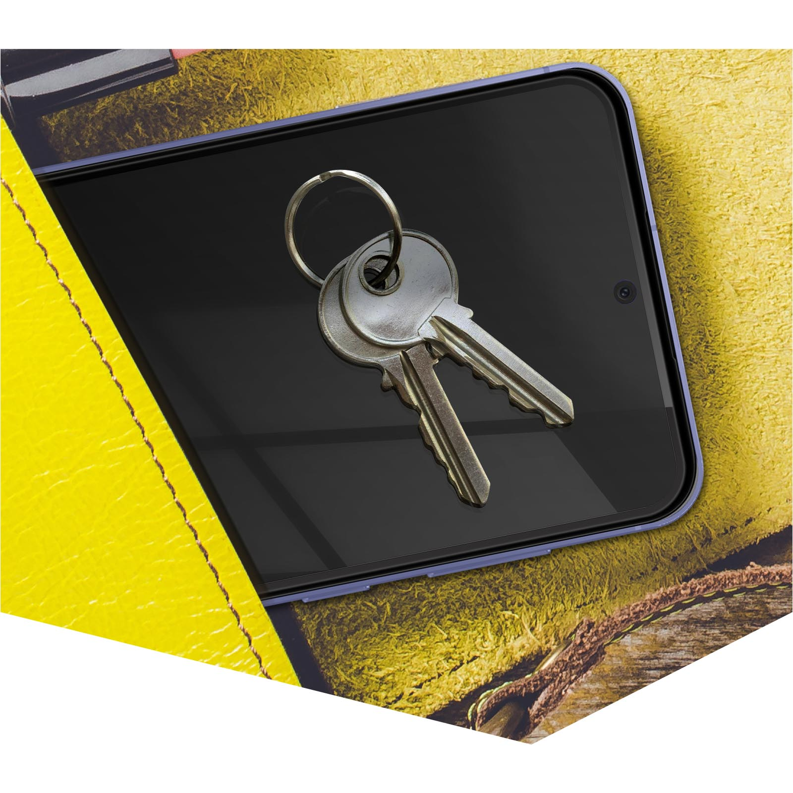 Klucze na ekranie telefonu, na żółtej, teksturowanej powierzchni, tło imitujące skórę.