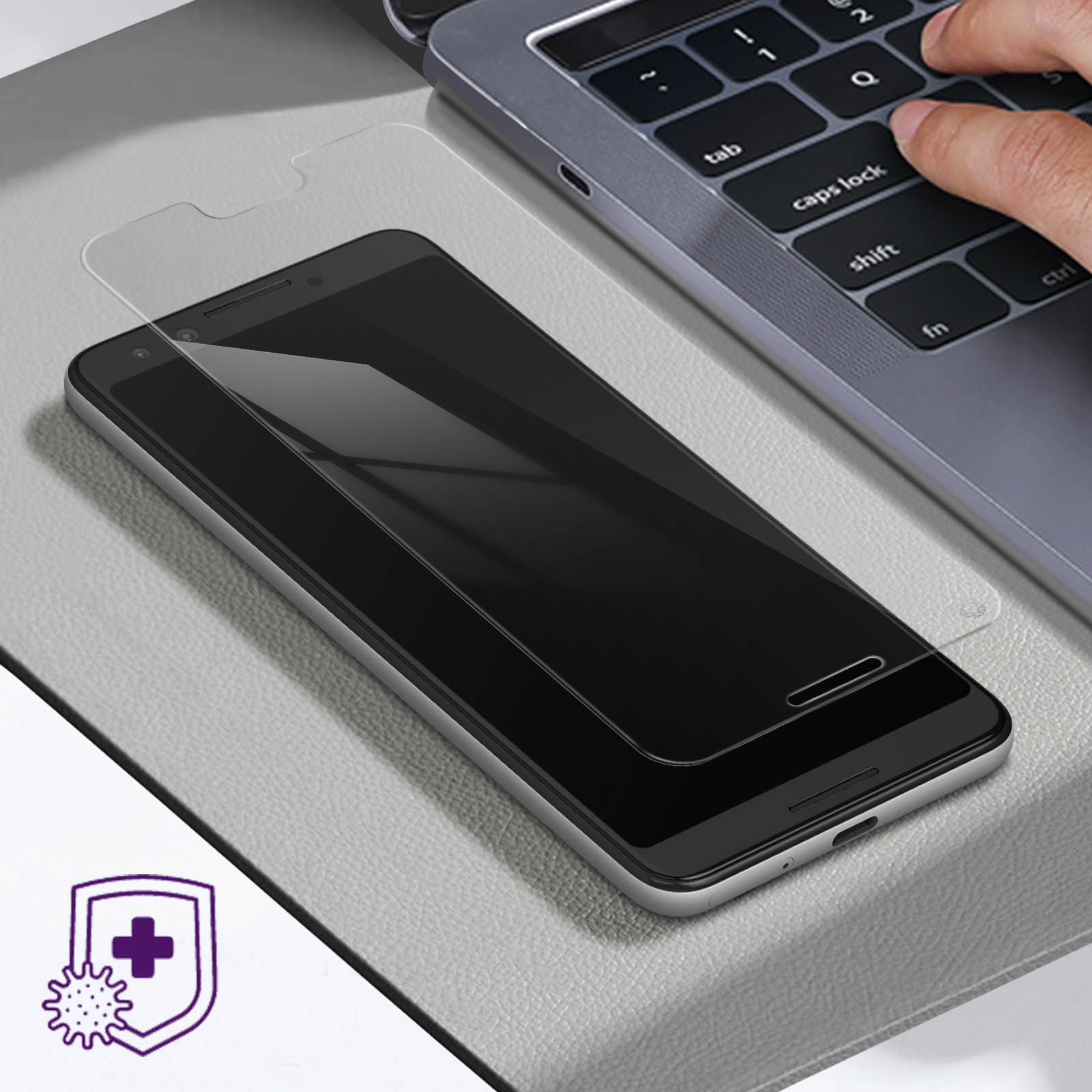 Telefono con protezione schermo su superficie grigia con un laptop.