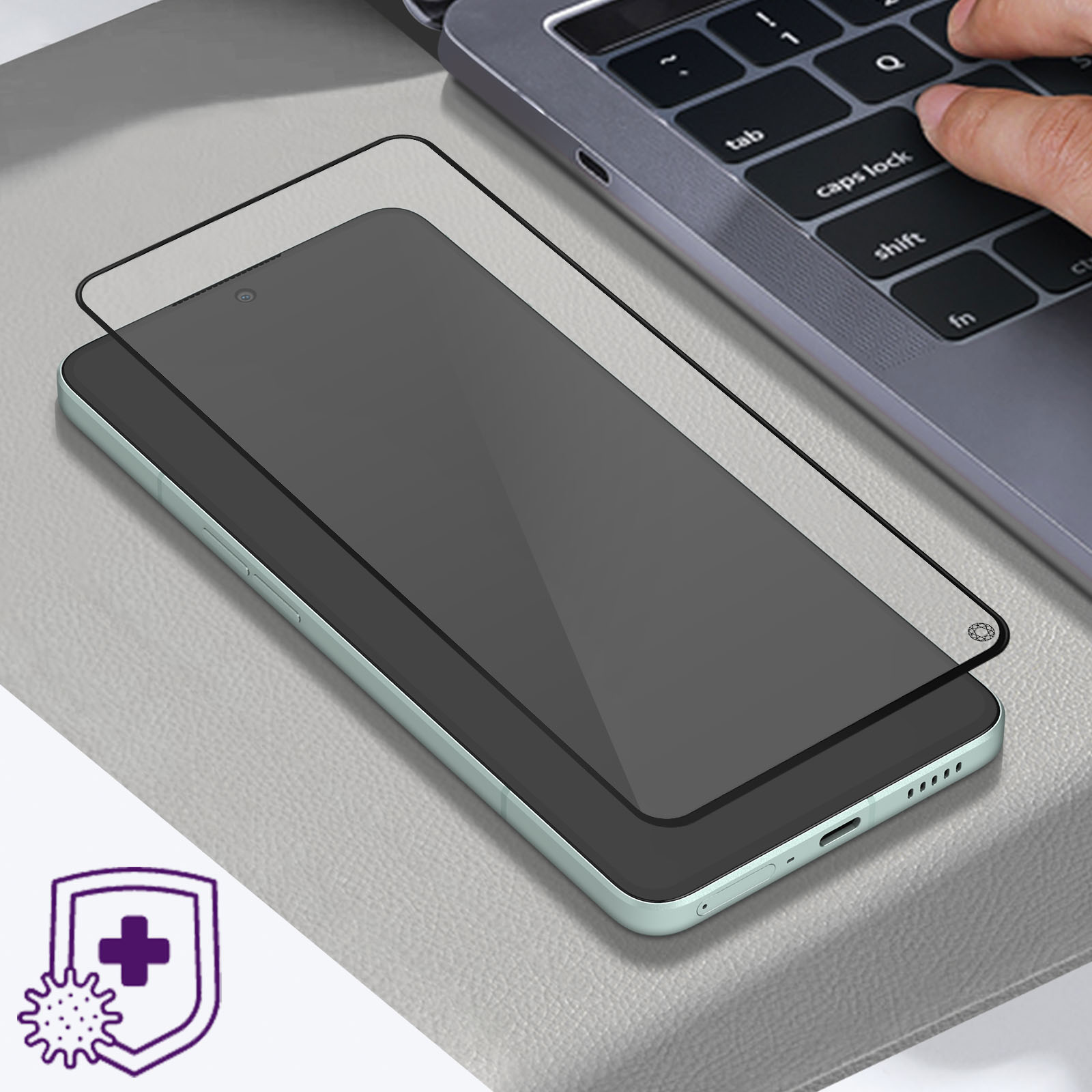 Een telefoon met een schermbeschermer en een laptop op de achtergrond. Er wordt een laptop gebruikt.