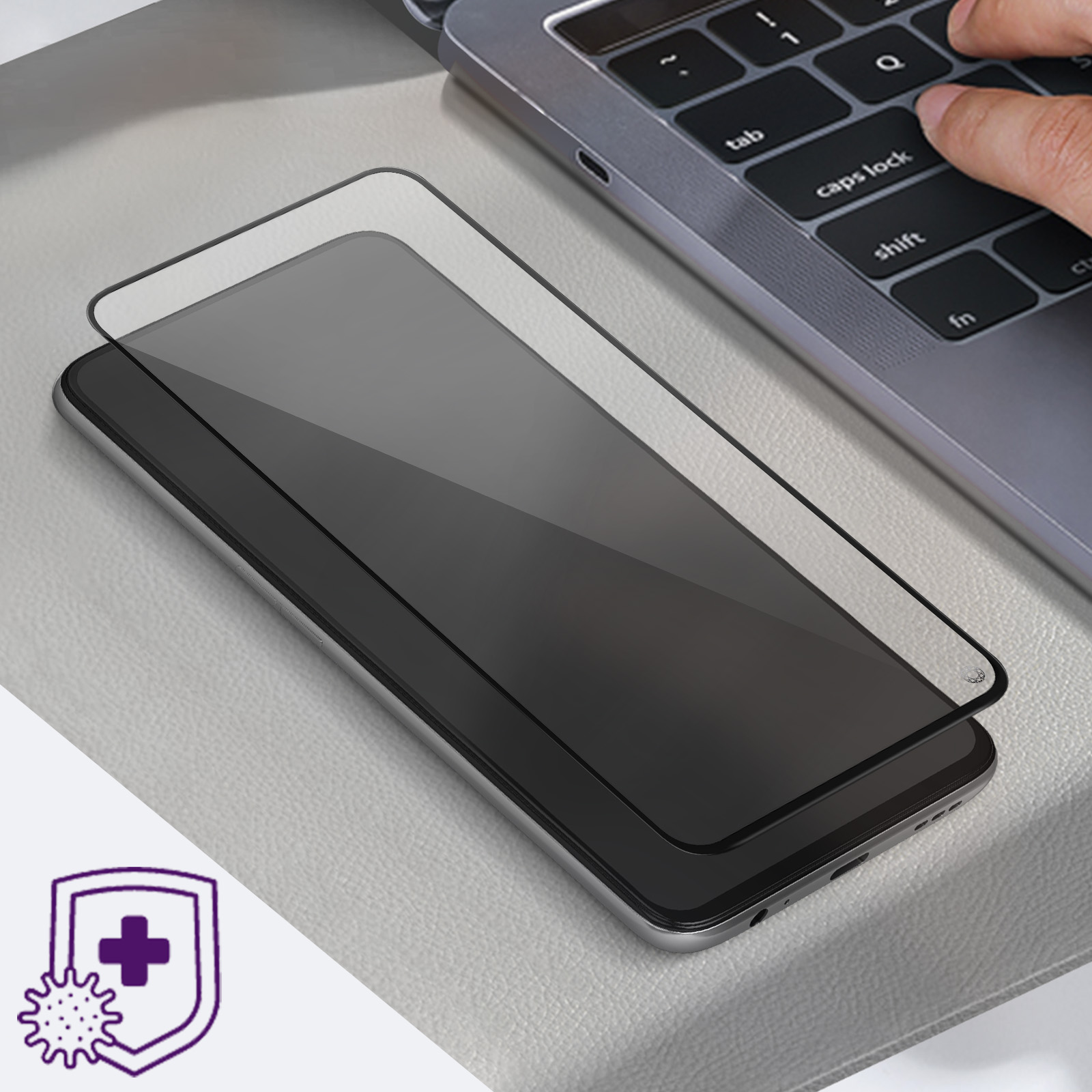 Uno smartphone nero con protezione schermo è su una superficie chiara, una tastiera portatile sullo sfondo.