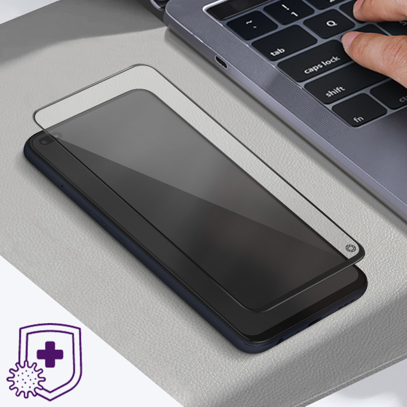 Schermo di smartphone con protezione schermo applicata da una mano su una tastiera di un laptop.