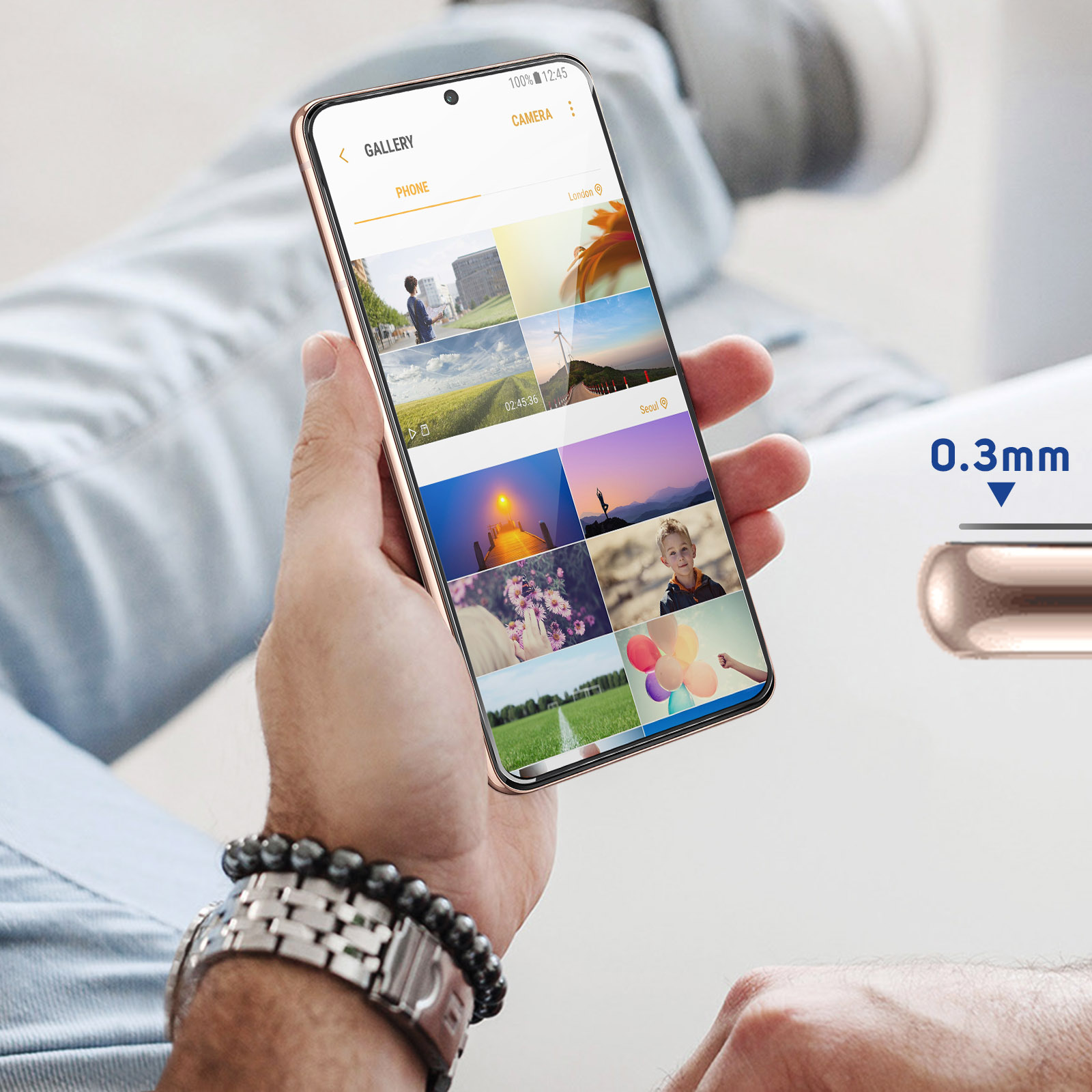 Osoba trzyma telefon wyświetlający zdjęcia z galerii. Telefon ma złotą ramkę i ma grubość 0,3 mm.