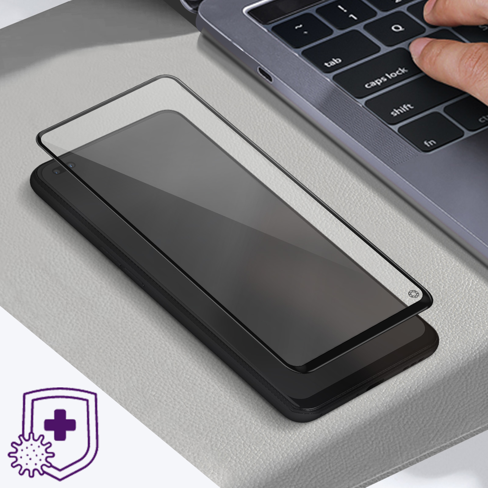 Un telefono su una superficie grigia con una protezione per lo schermo e una tastiera del laptop sullo sfondo.