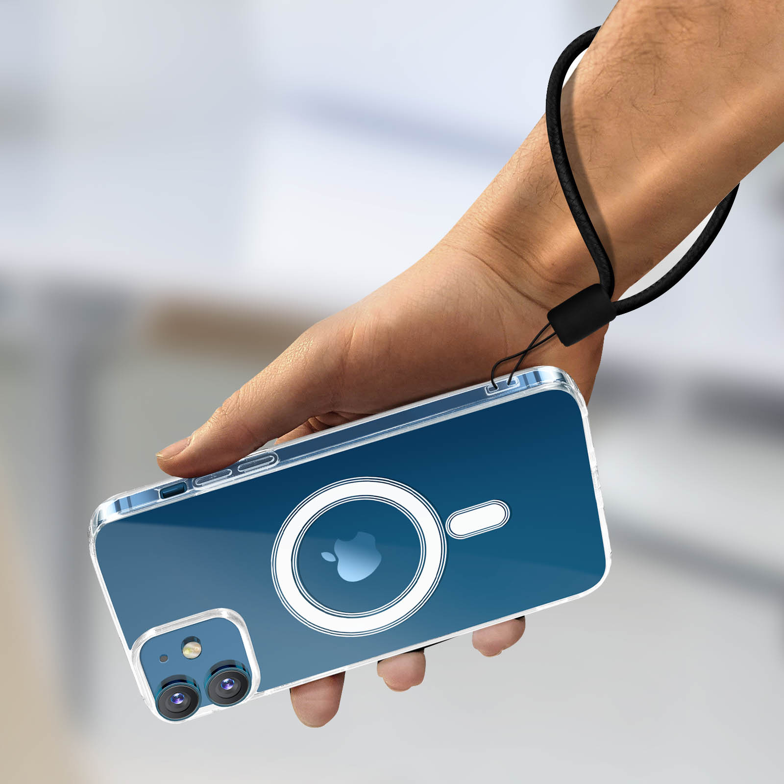 Main tenant un téléphone avec une coque transparente. L'arrière-plan est une rue floue.