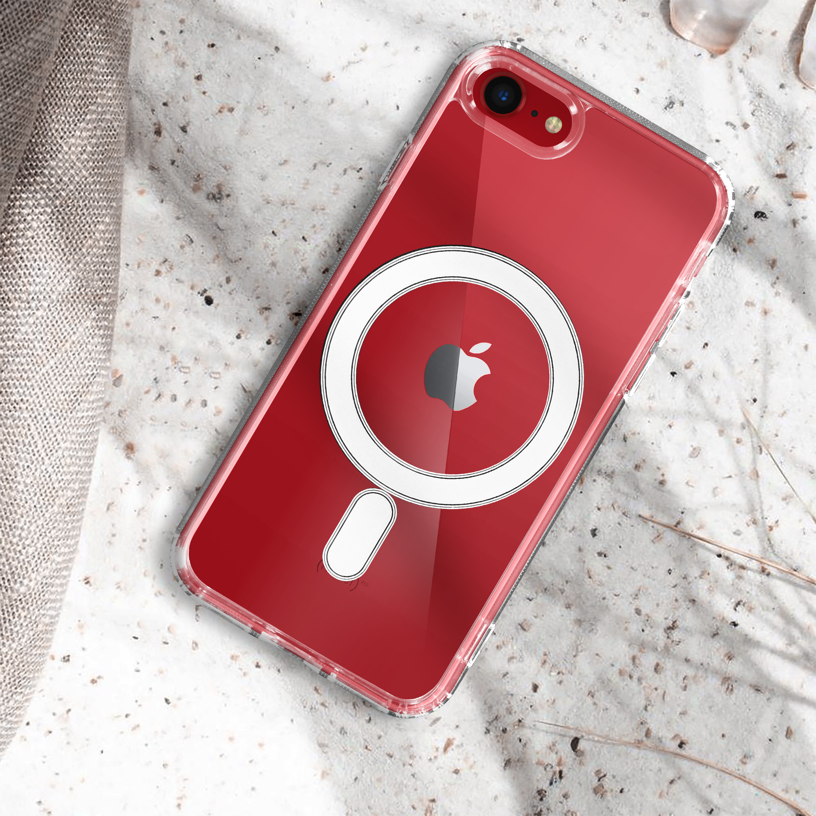 Un iPhone rosso in una custodia trasparente con un caricatore MagSafe circolare bianco su una superficie strutturata.