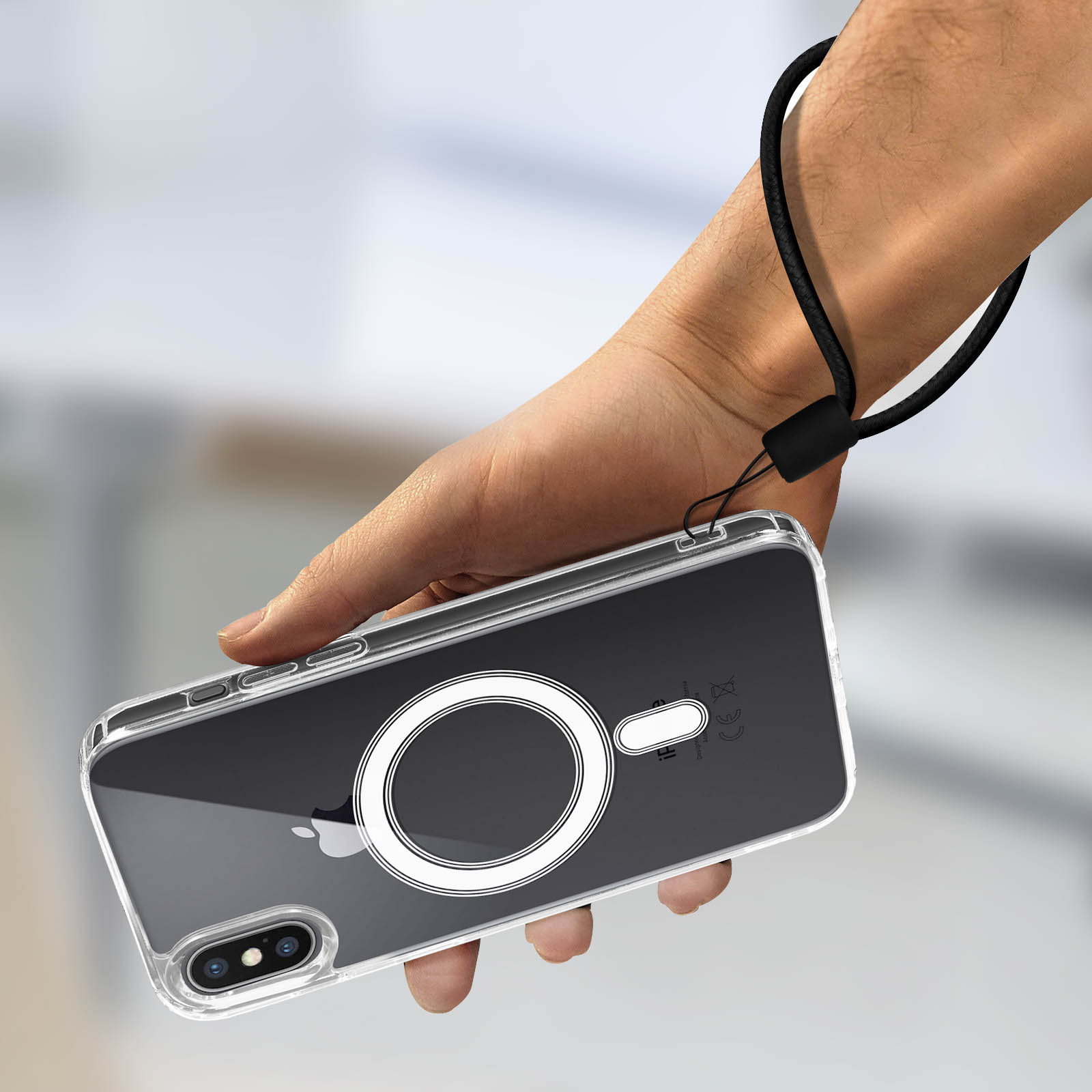 Mano che tiene una custodia trasparente con un cinturino. La custodia ha un MagSafe circolare bianco.