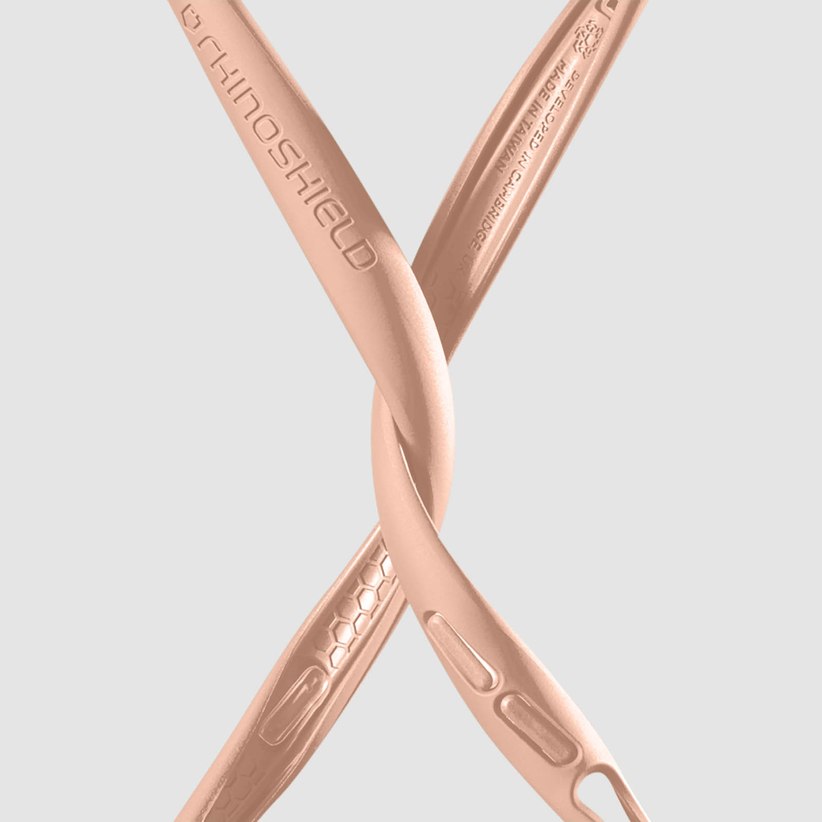 Dos fundas entrelazadas de color oro rosa, con la marca 'RhinoShield' visible.