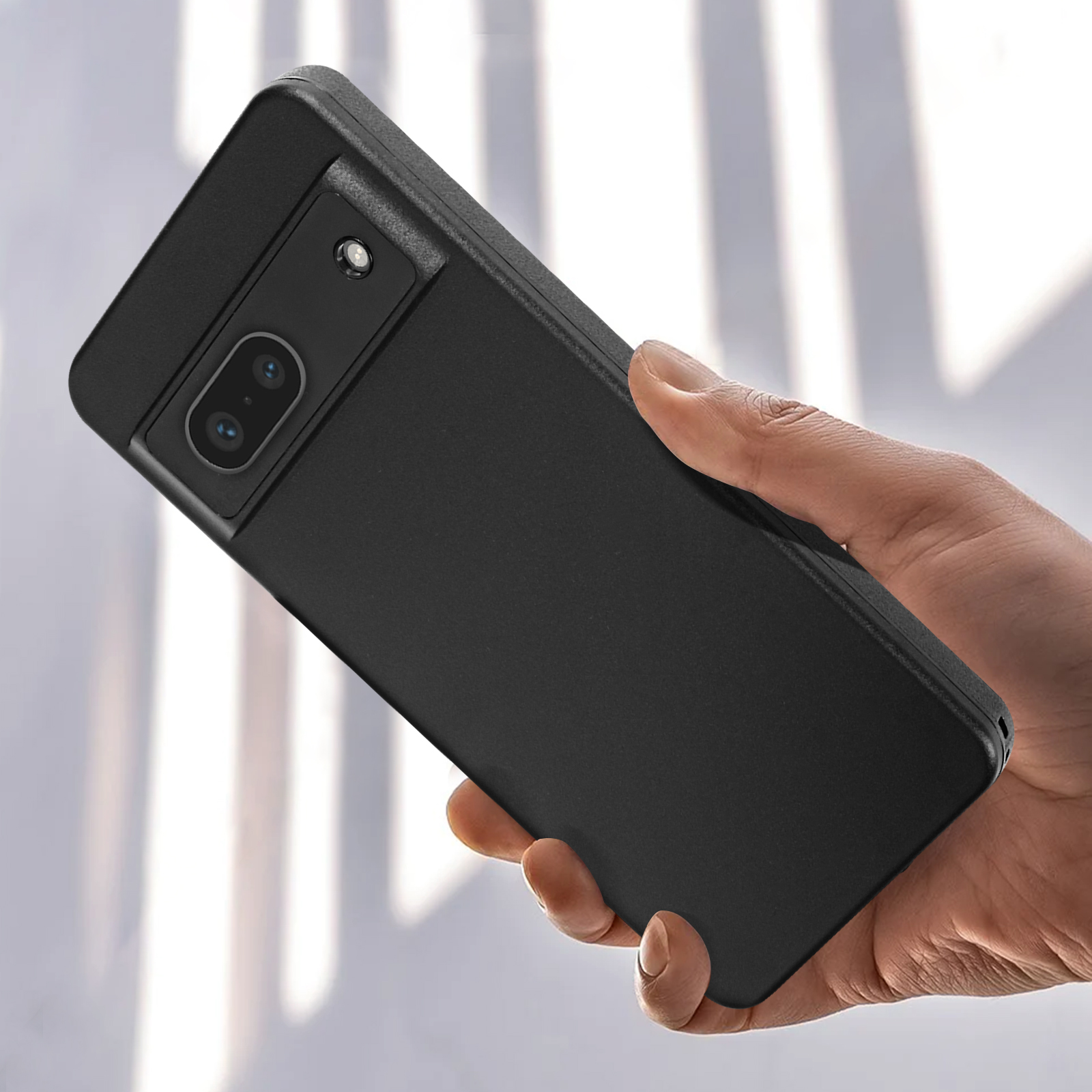 Una custodia nera per telefono tenuta in mano. La custodia ha un ritaglio per la fotocamera e un design strutturato.
