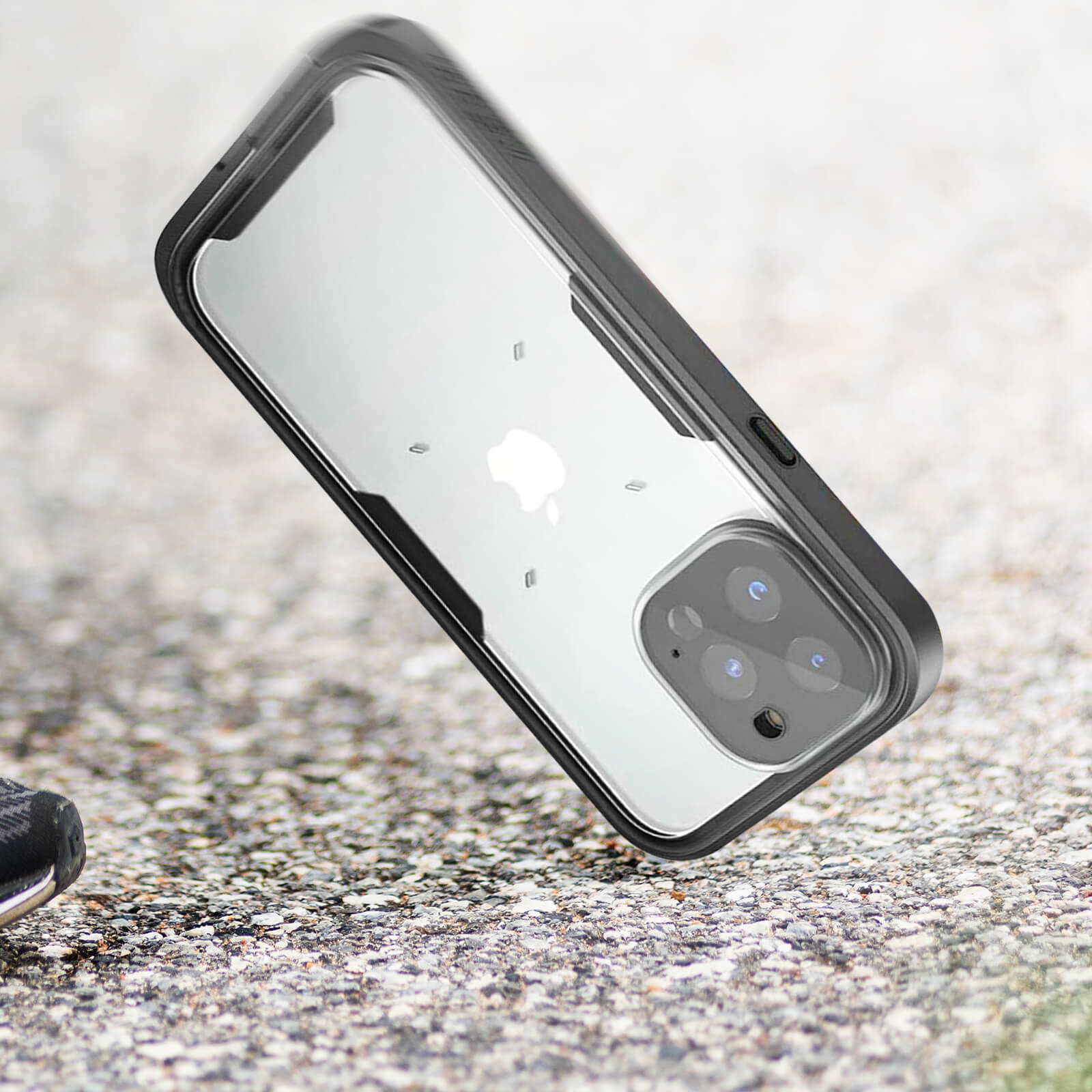 Ein Telefon in einer schwarzen Hülle liegt auf einer rauen Oberfläche. Die Hülle hat eine klare Rückseite.