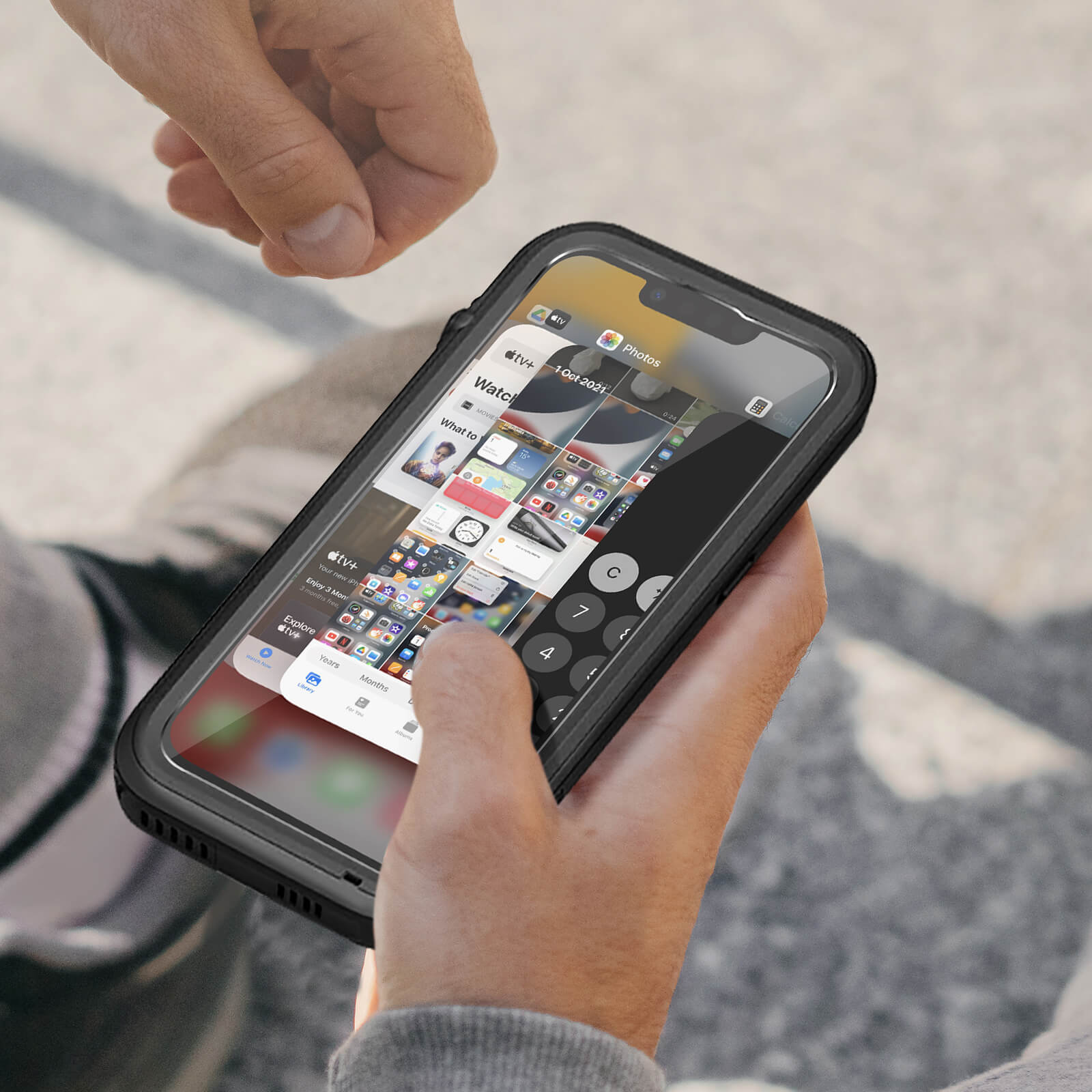 Eine Person hält ein Telefon in einer Hülle. Der Bildschirm zeigt eine Multi-Window-Oberfläche mit App-Symbolen.