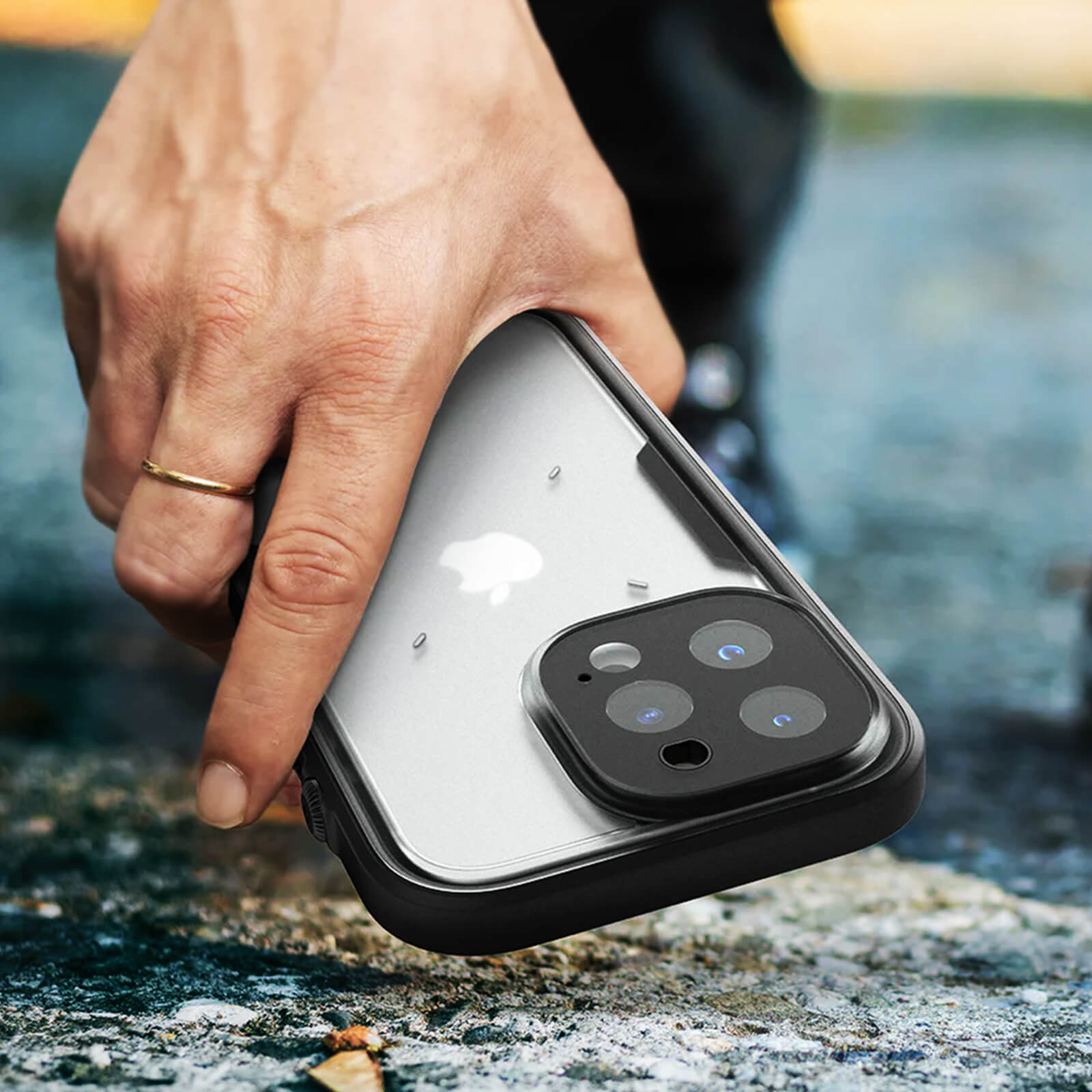 Eine Hand, die ein Telefon mit Hülle hält. Das Telefon ist schwarz und die Hülle ist transparent.