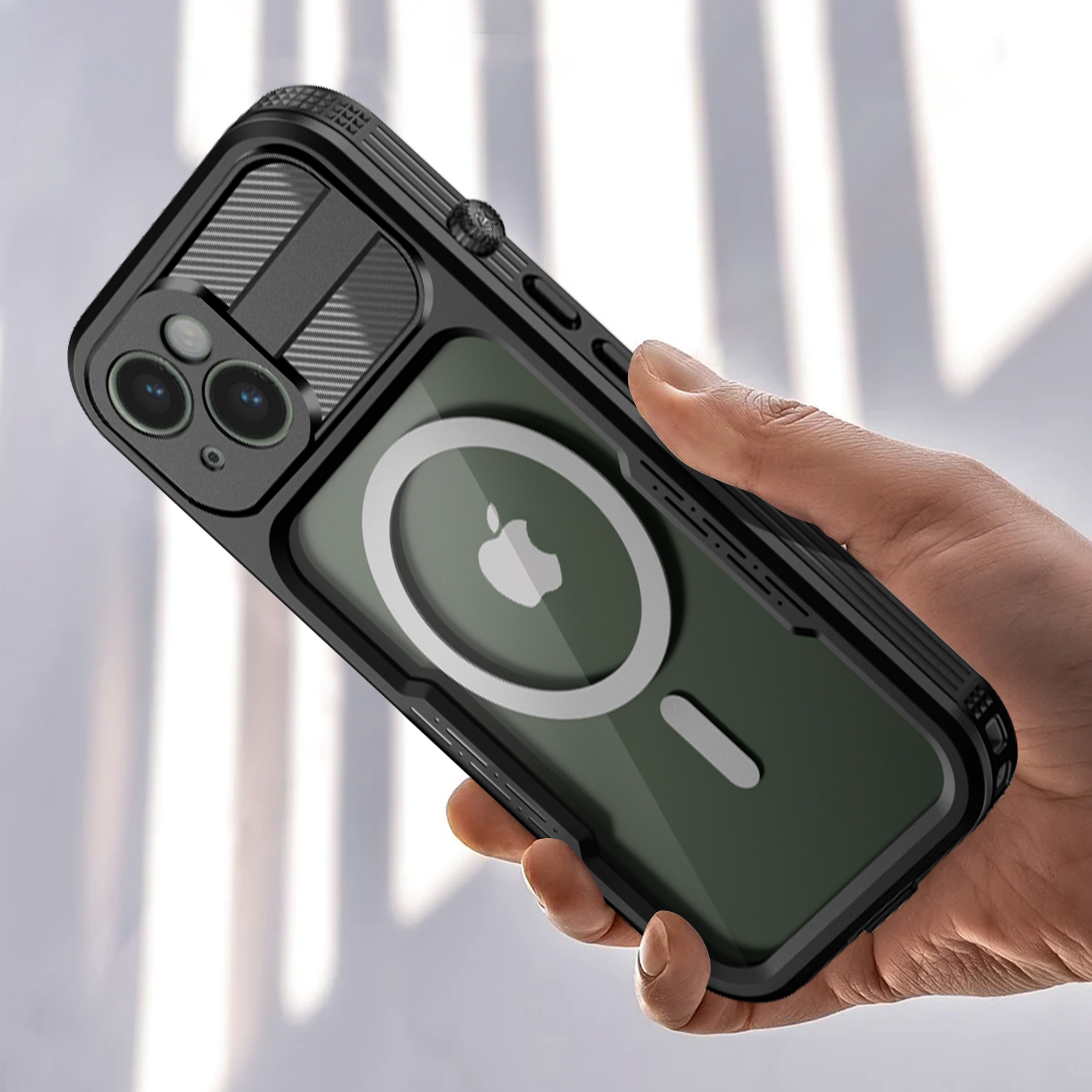 Mano che tiene una custodia nera con dettagli fotocamera e magsafe, logo Apple visibile.