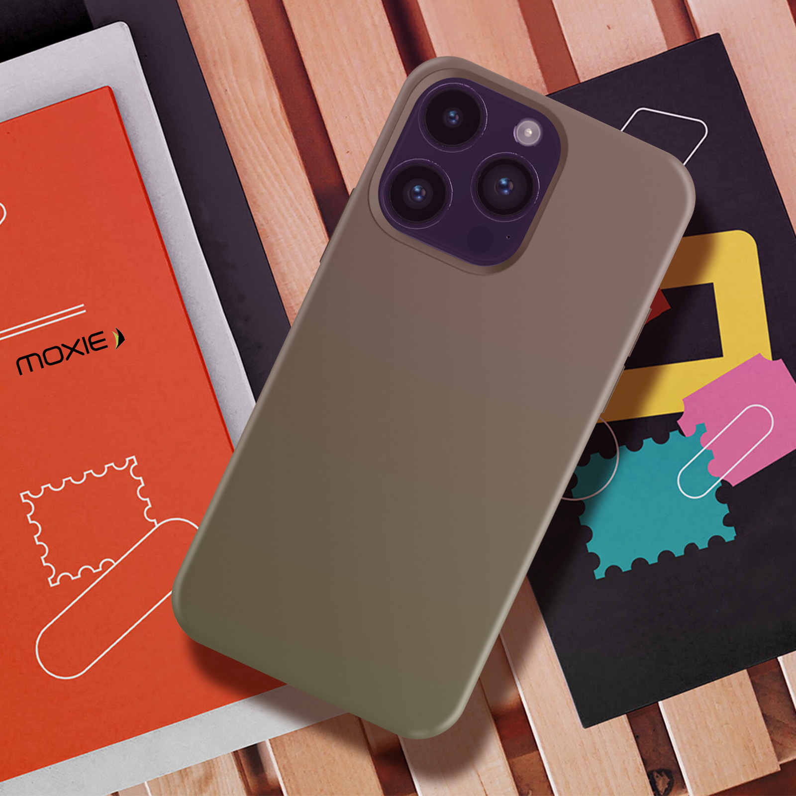 Un téléphone avec un étui marron sur des livres. Les livres sont sur une surface en bois.