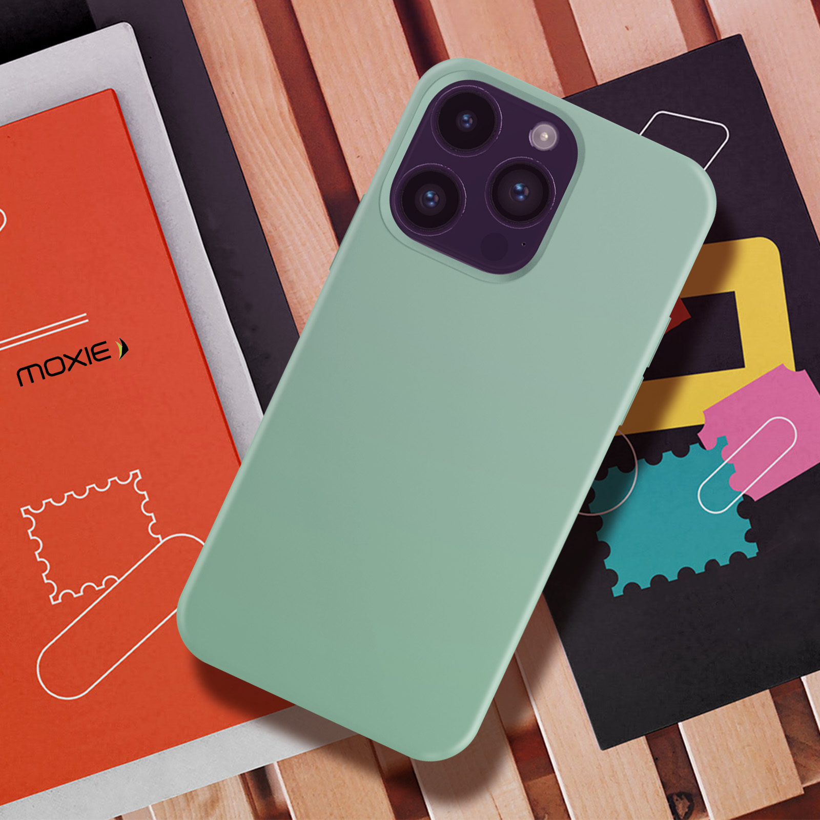 Een groene telefoonhoes met een telefoon erin. De telefoonhoes ligt op boeken.