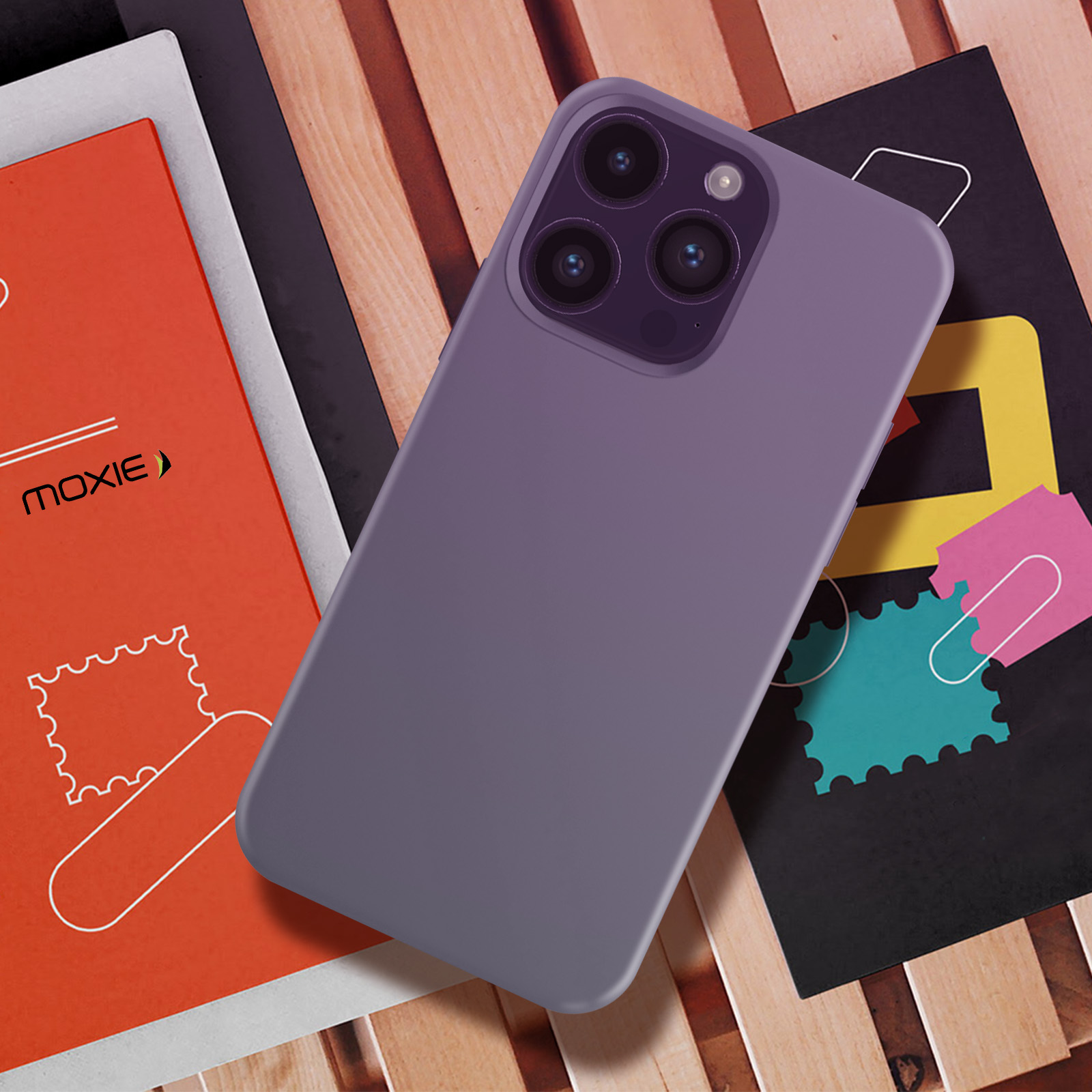 Custodia viola su libri, fotocamere del telefono visibili.