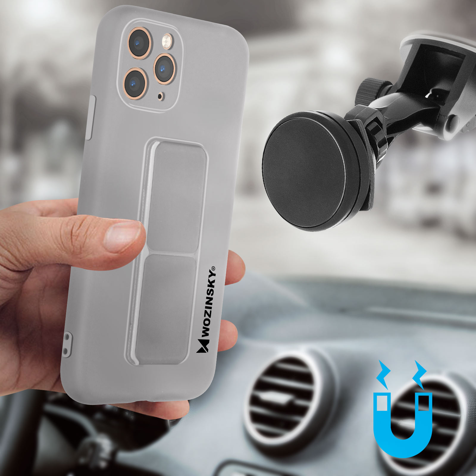 Dłoń trzymająca szary telefon z magnetycznym uchwytem samochodowym. Tło jest rozmyte.